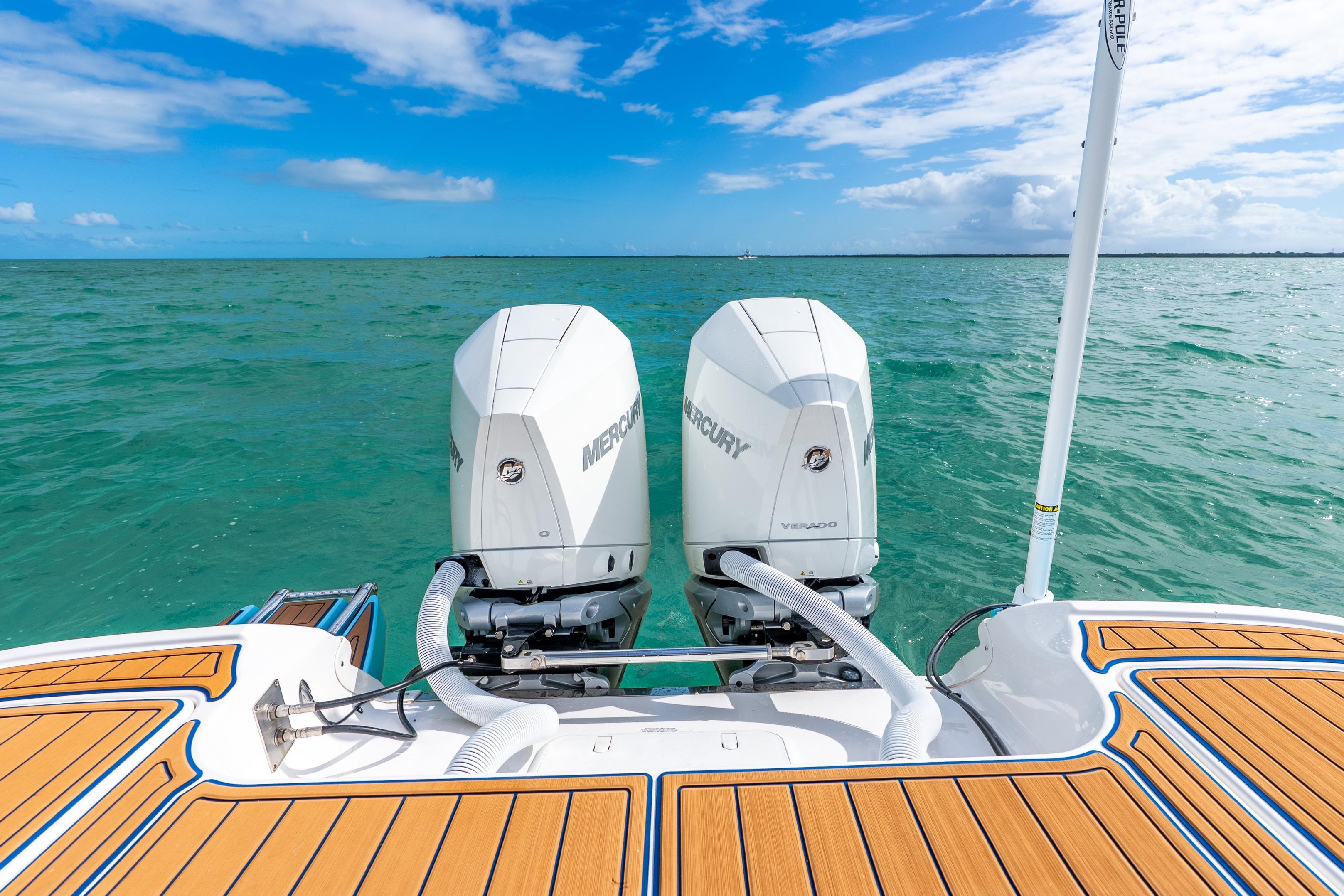 2024 Caymas 281 HB boat with dual Mercury engines on turquoise water.
