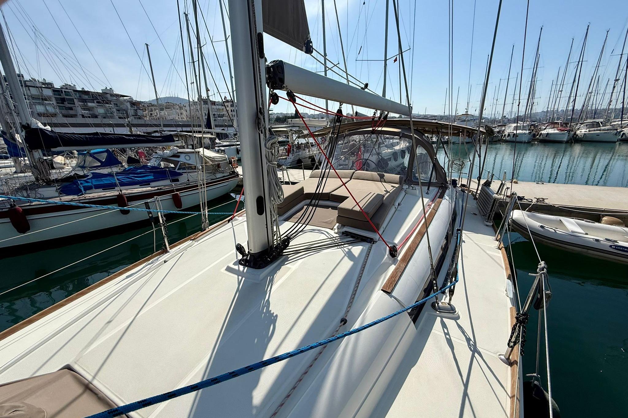 2018 Jeanneau Sun Odyssey 389 sailboat docked in a marina, surrounded by other boats.