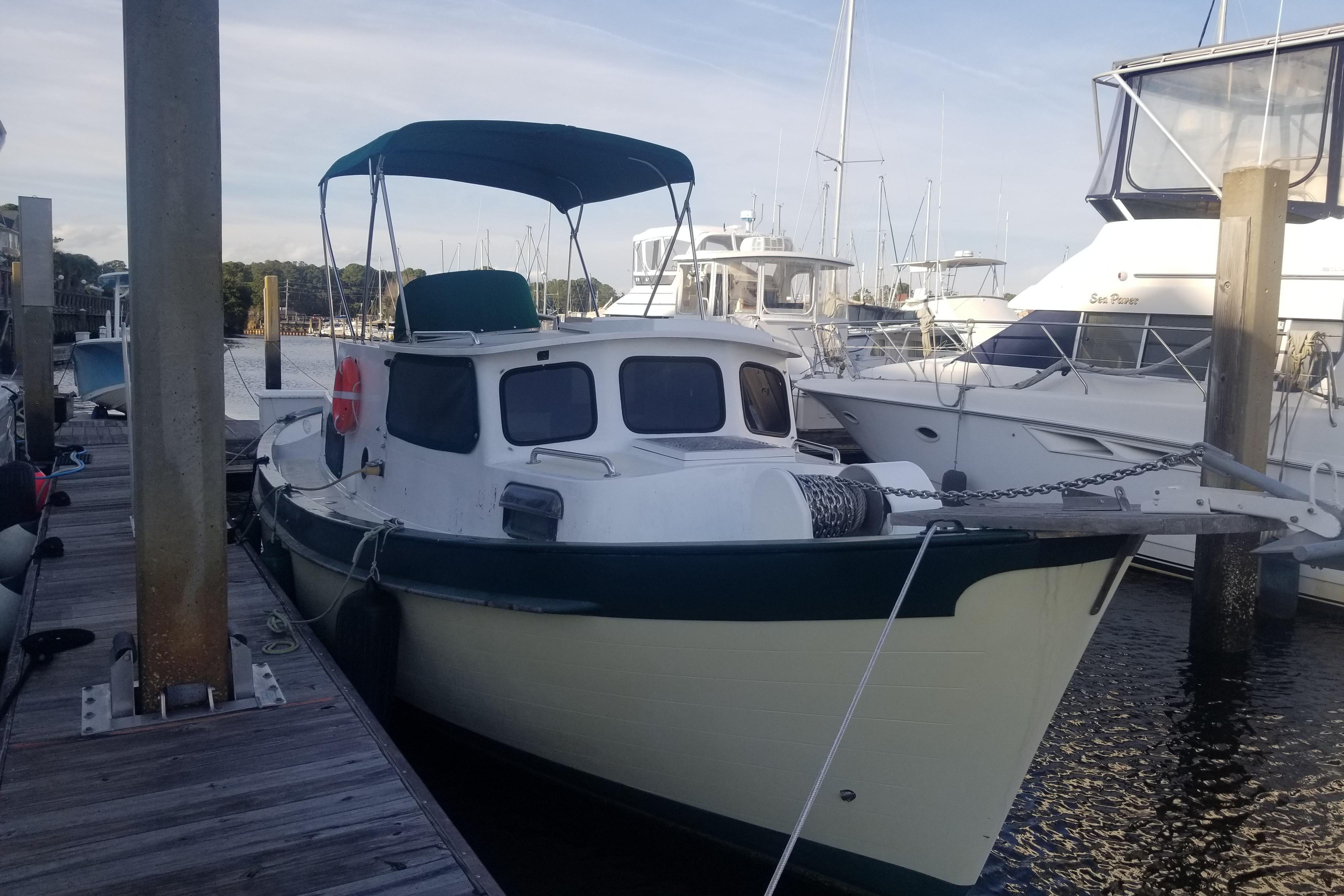 1974 Fales Navigator boat docked at marina, featuring classic design and canopy.