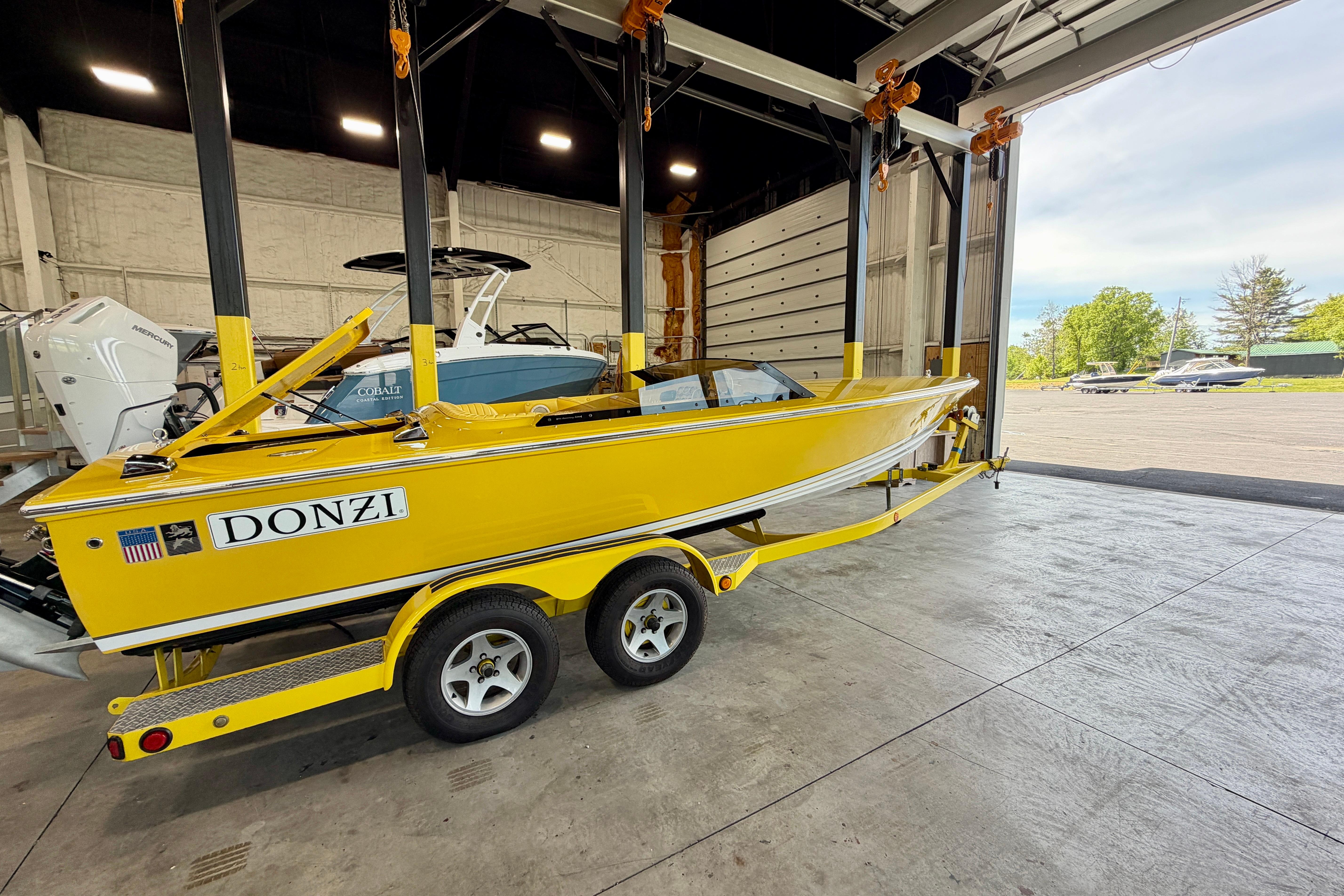 Yellow 2004 Donzi 22 Classic boat on trailer in a garage setting.