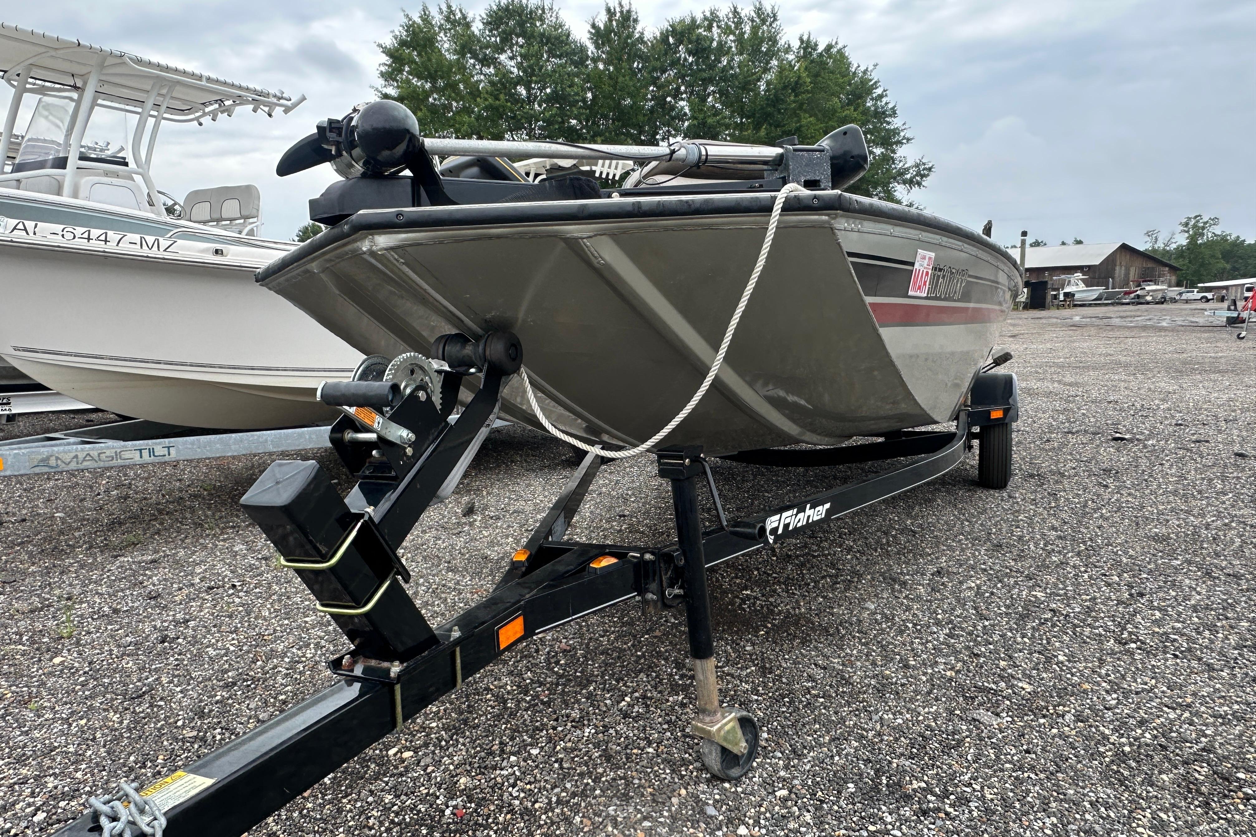 2002 Fisher 1710 boat on trailer, parked outdoors on gravel lot.
