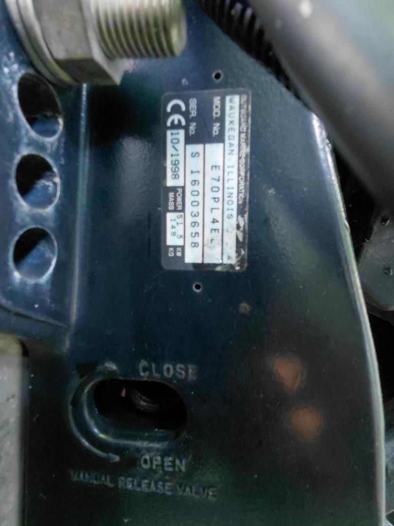 Close-up of a boat part with serial number and valve labeling.