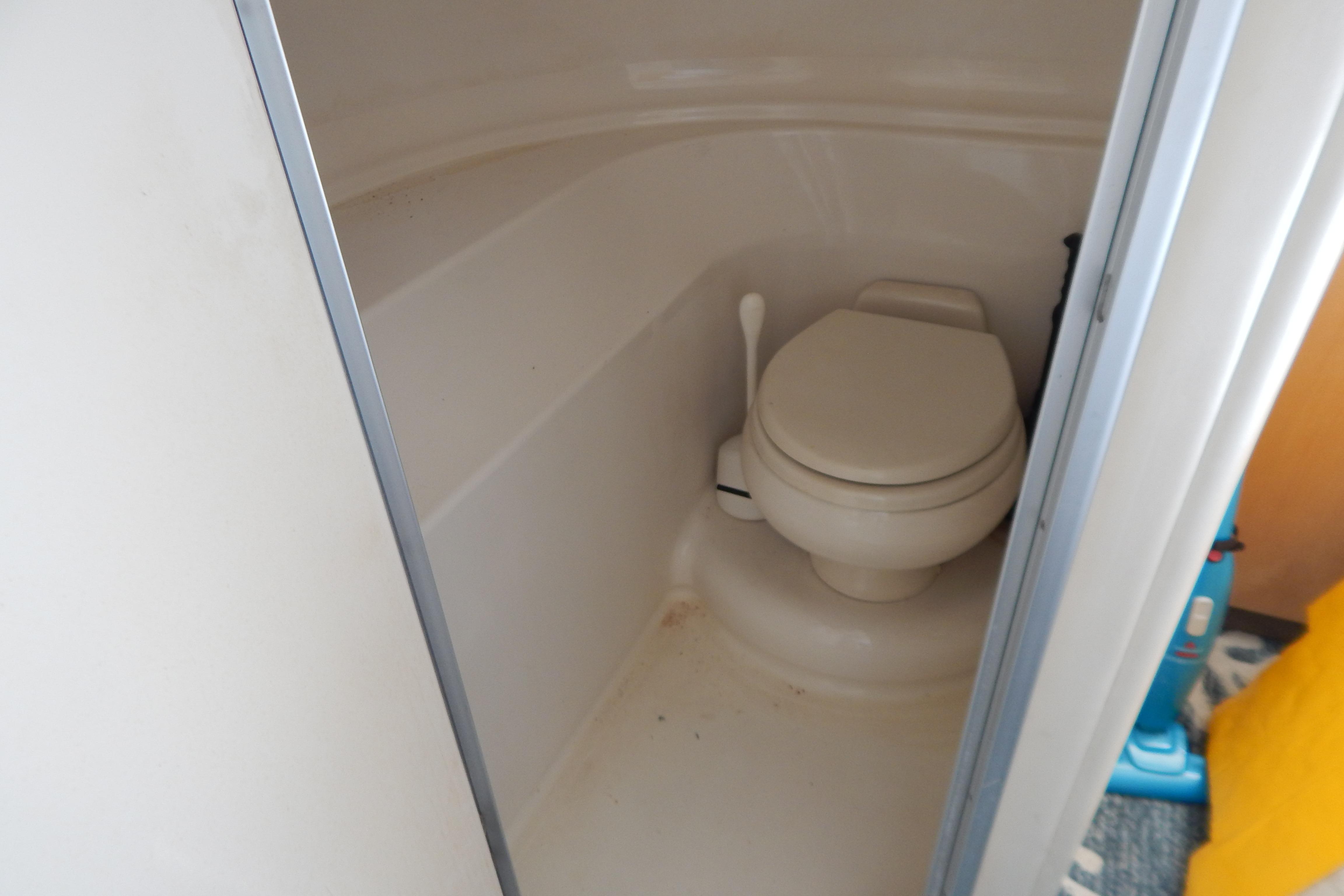 Compact bathroom with toilet in 1998 Magnum 4100 SCR boat.
