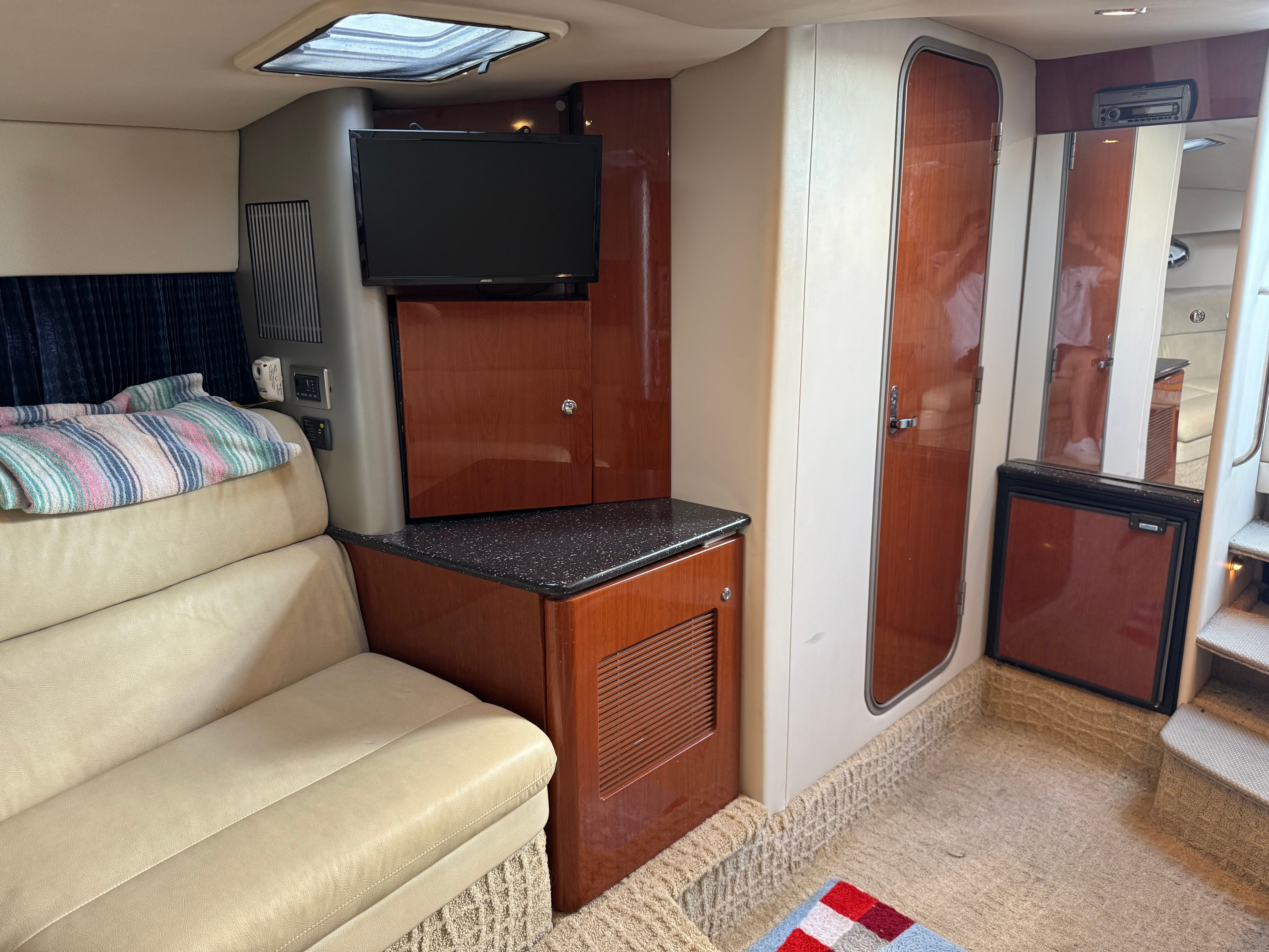 Interior of a yacht with a sofa, TV, and wooden cabinetry.