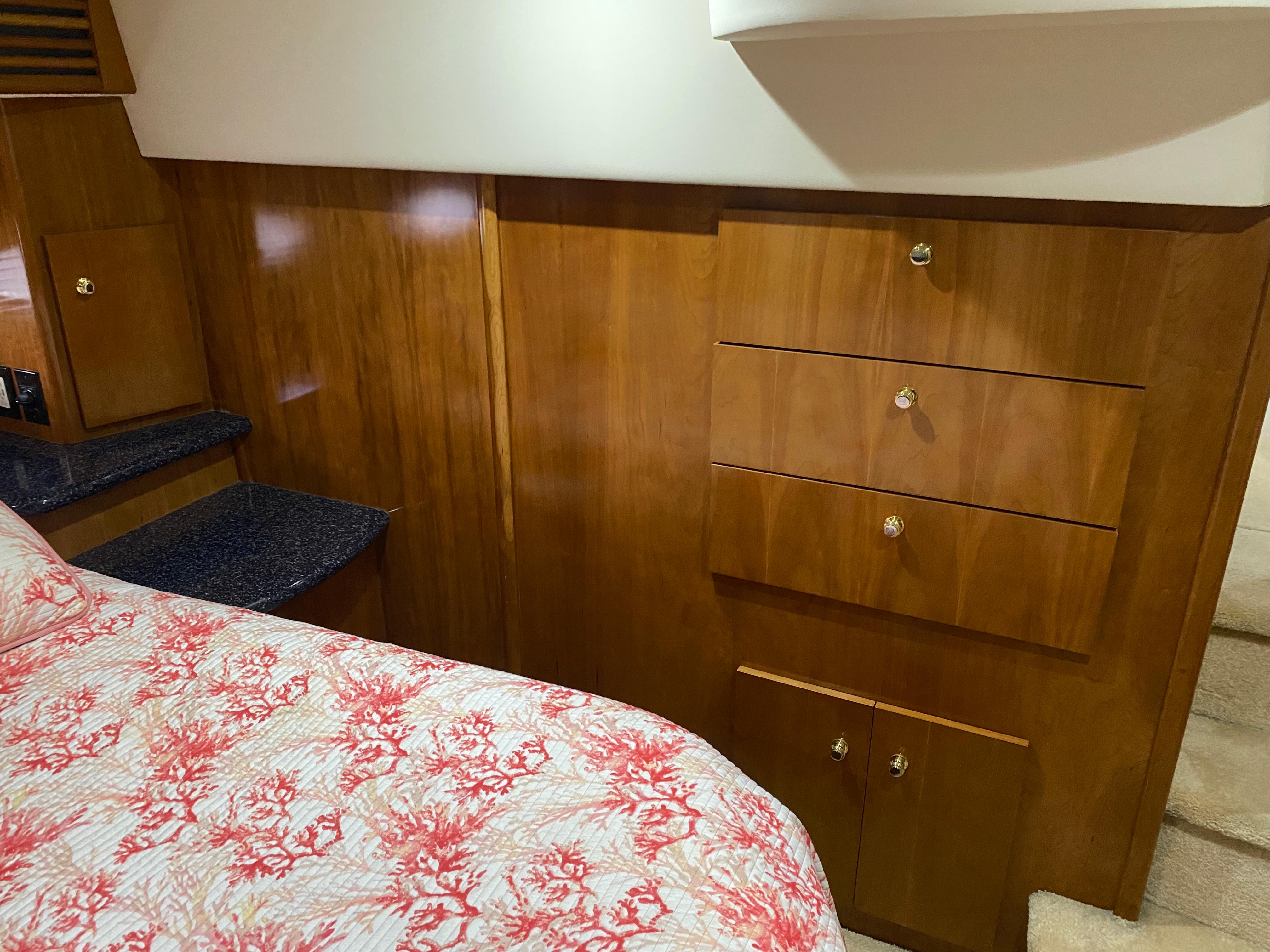 Interior of 2000 Carver 396 Motor Yacht with wooden cabinetry and floral bedspread.