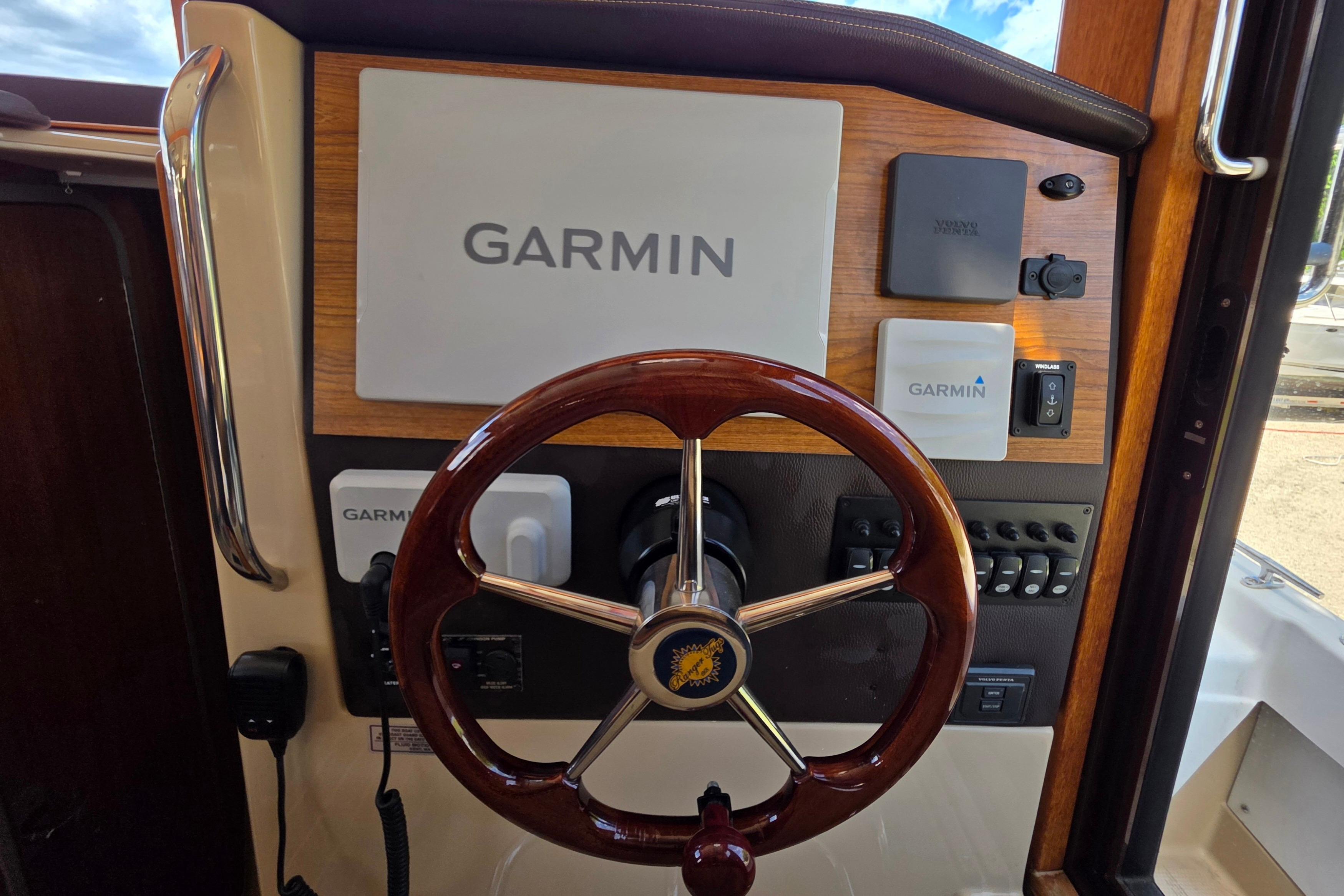 2020 Ranger Tugs R-31 CB helm with Garmin navigation system and wooden steering wheel.