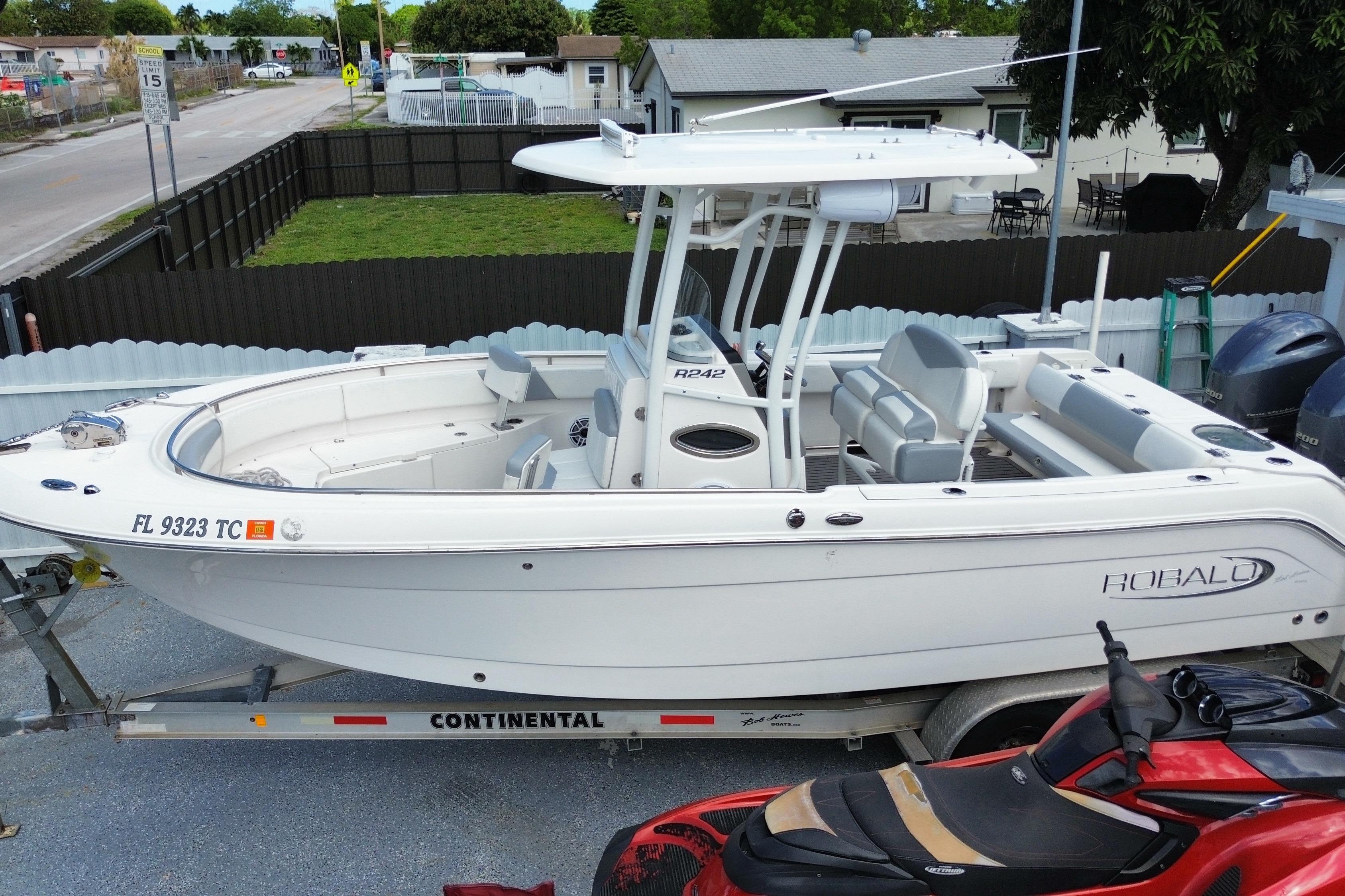 2022 Robalo R242 Center Console boat on trailer, parked in residential area.