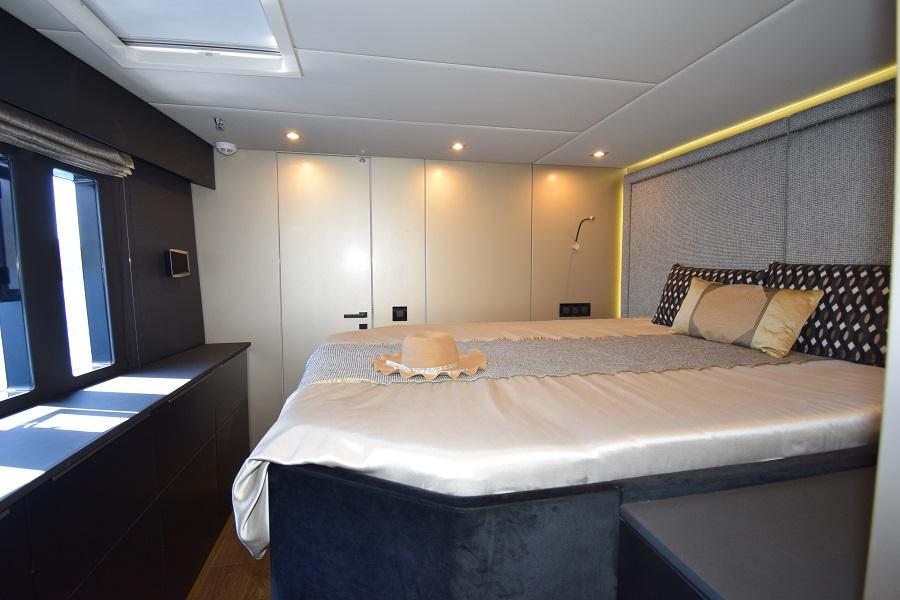 Luxurious bedroom interior of 2019 Sunreef 50 yacht with elegant bedding and modern lighting.