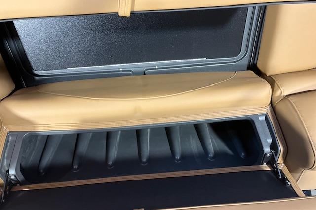 Interior storage compartment of 2026 Regency 230 DL with tan leather seating.