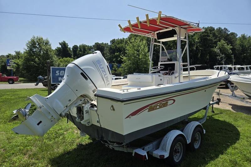 2000 May-Craft 2000CC boat with Suzuki outboard motor on trailer, parked on grass.