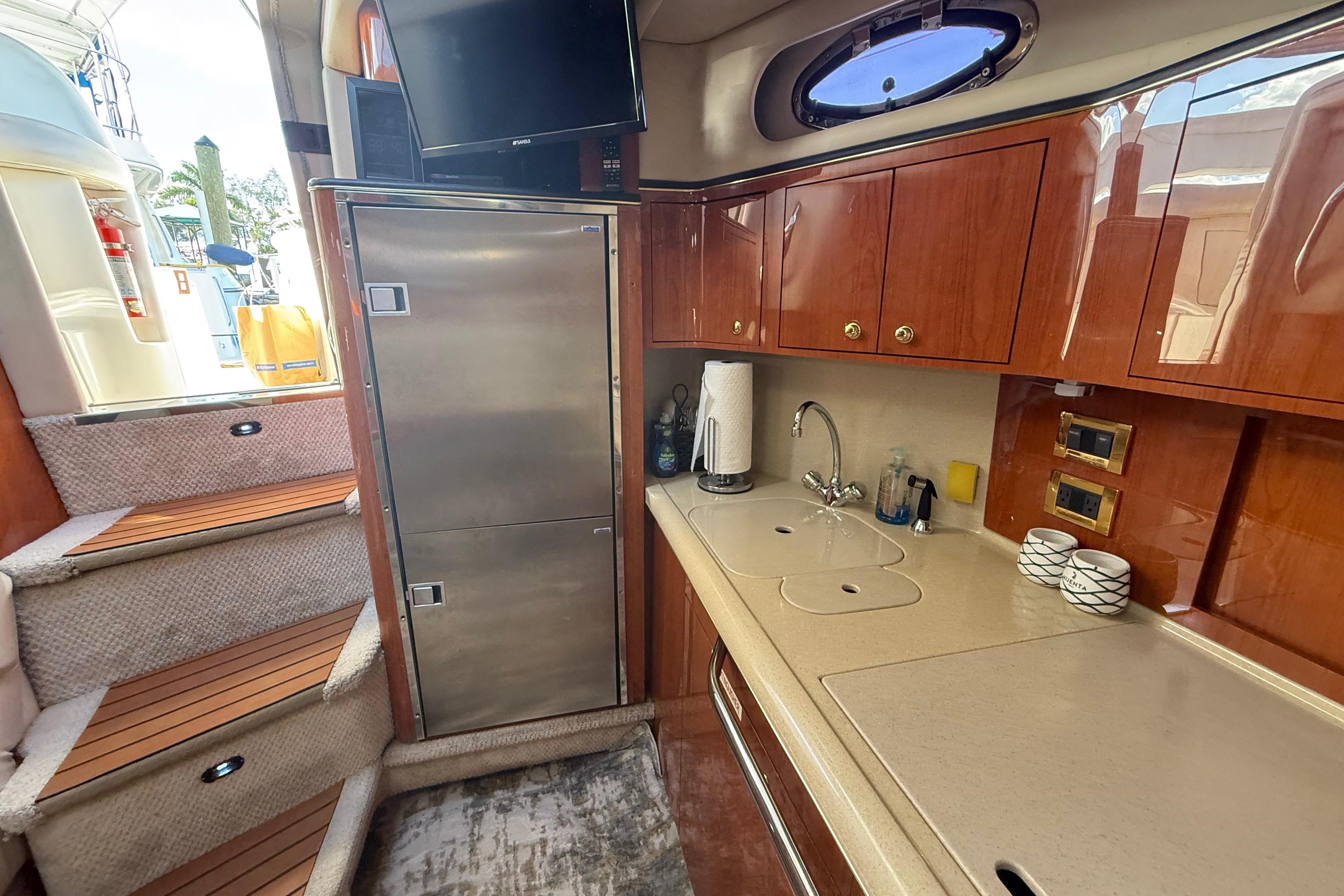 Interior of 1999 Sea Ray 410 Express Cruiser with kitchenette and stairs.