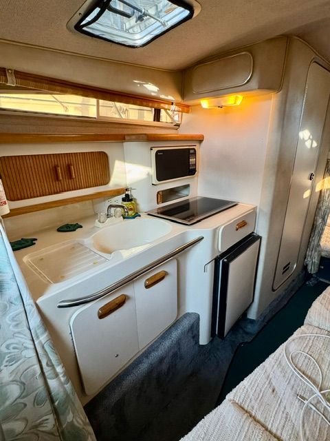 Interior of the 1992 Sea Ray 290 Sundancer featuring a kitchen and sleeping area.