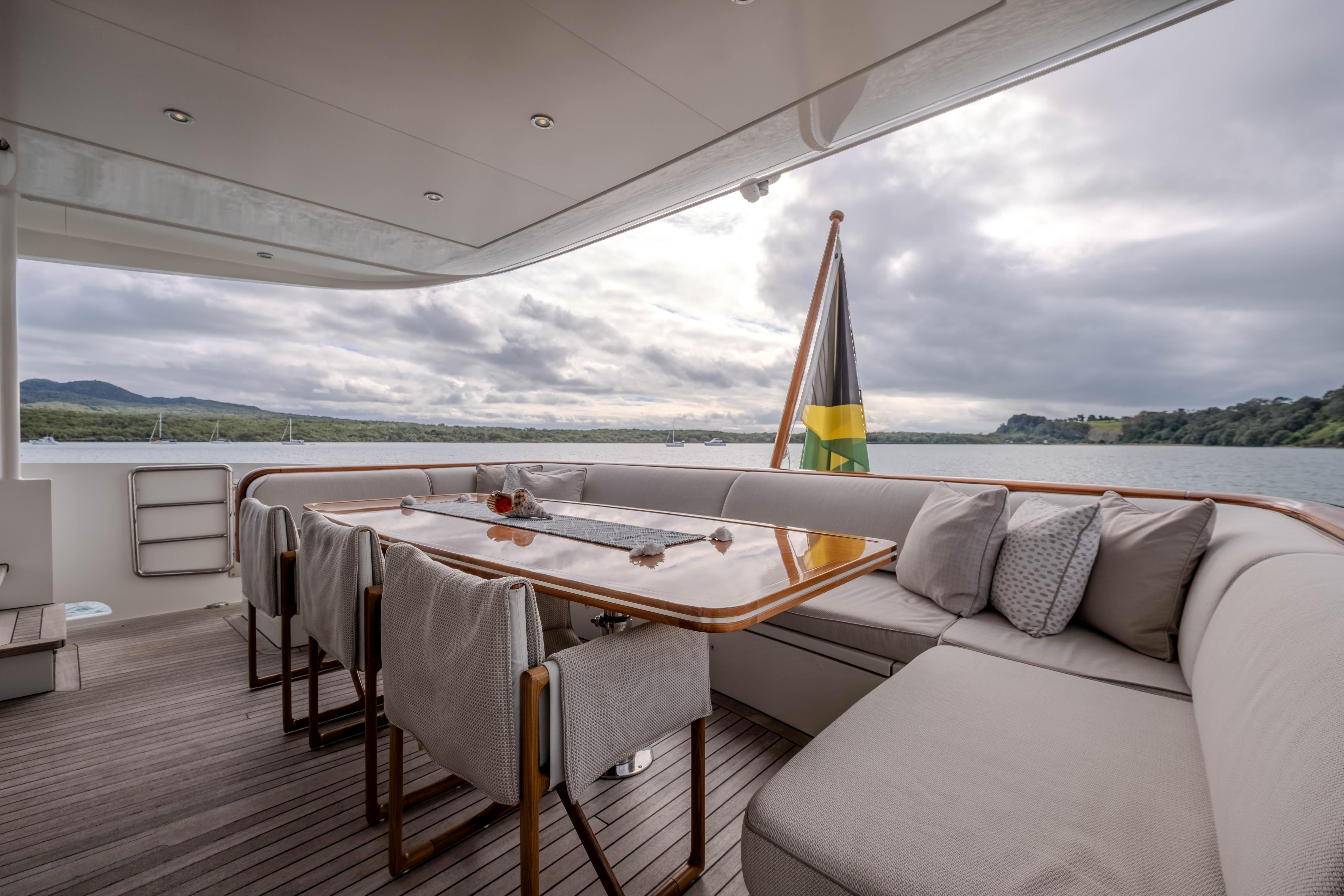 Luxurious Mulder 98 Flybridge yacht deck with elegant seating, dining area, and scenic water view.