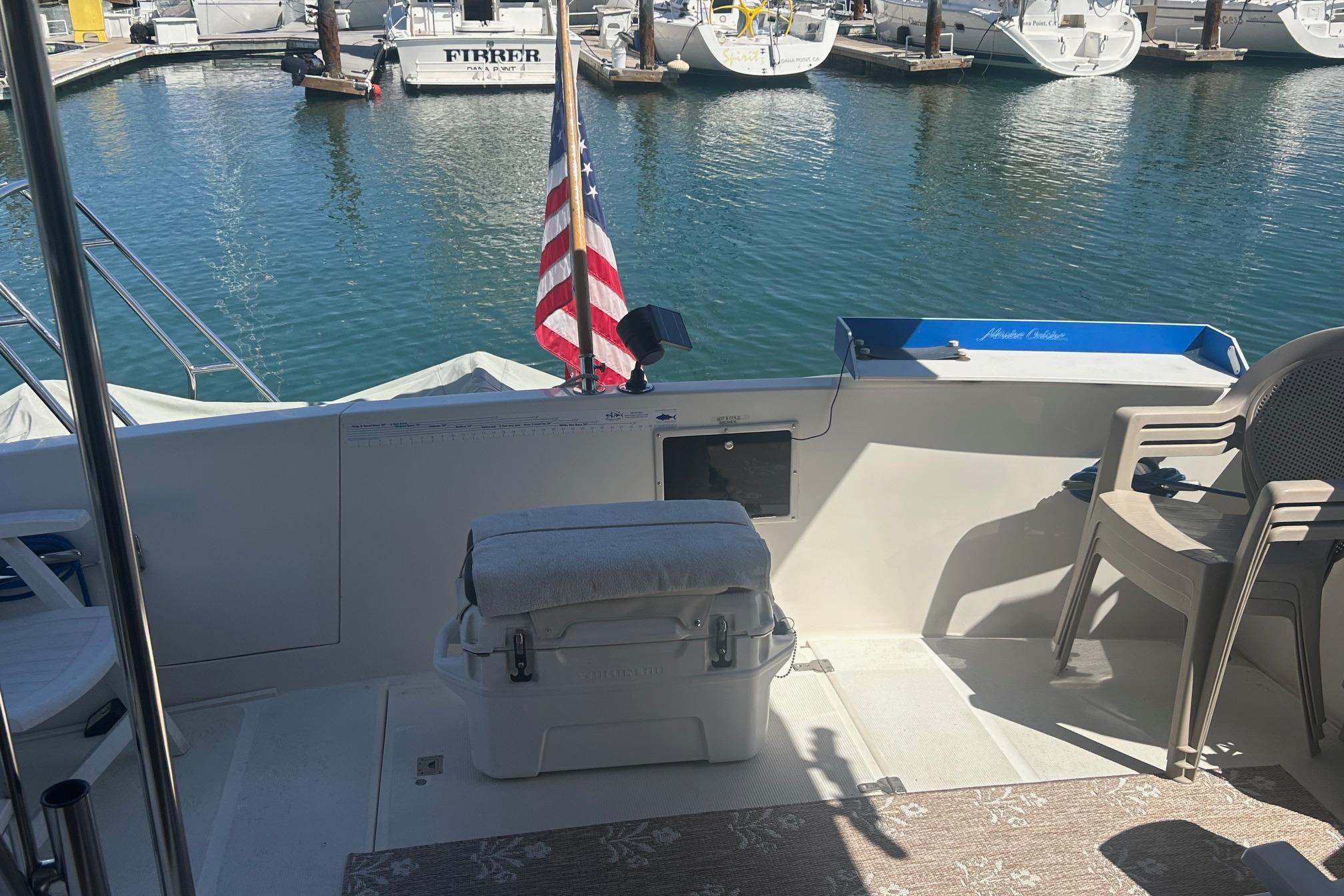 1991 Ocean Alexander 420 Sport Sedan yacht deck with American flag at marina.