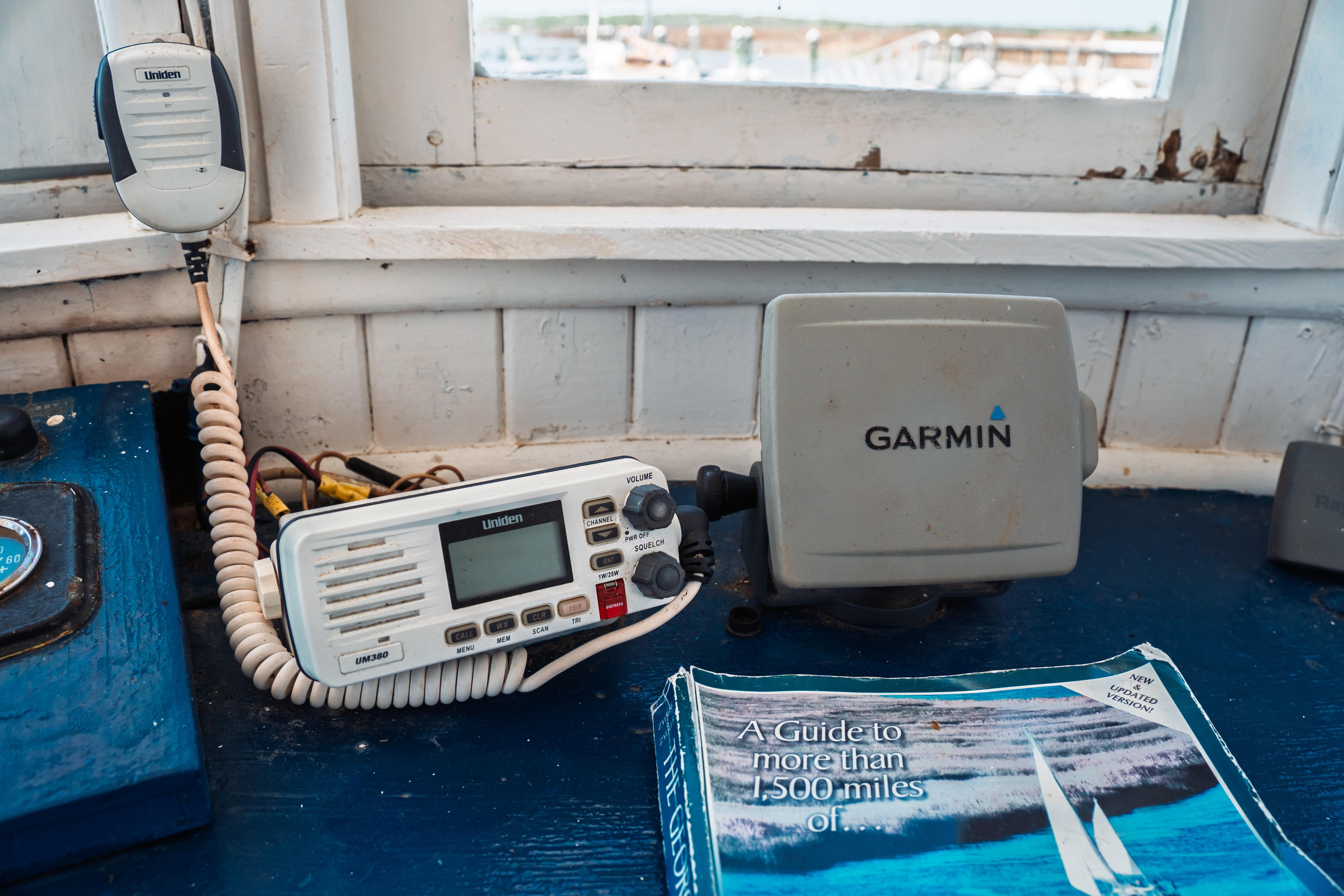 1977 Saint Augustine Trawler 43 cockpit with Uniden radio, Garmin GPS, and nautical guidebook.