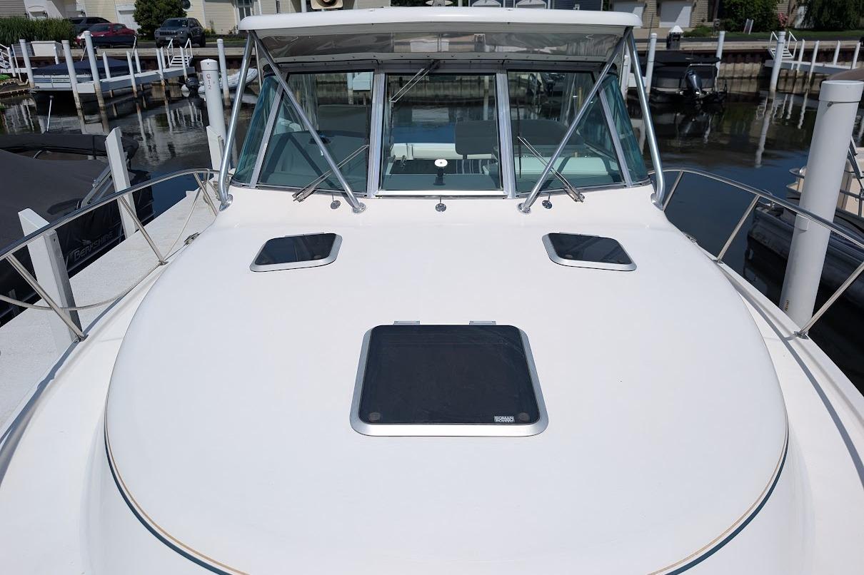 2000 Pursuit 3400 Express boat docked, showcasing sleek deck design and windows.