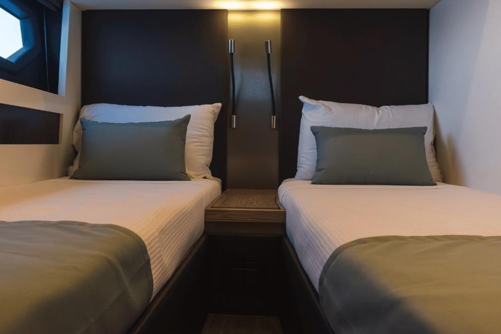 Interior of 2020 Azimut 60 yacht featuring twin beds with elegant bedding.