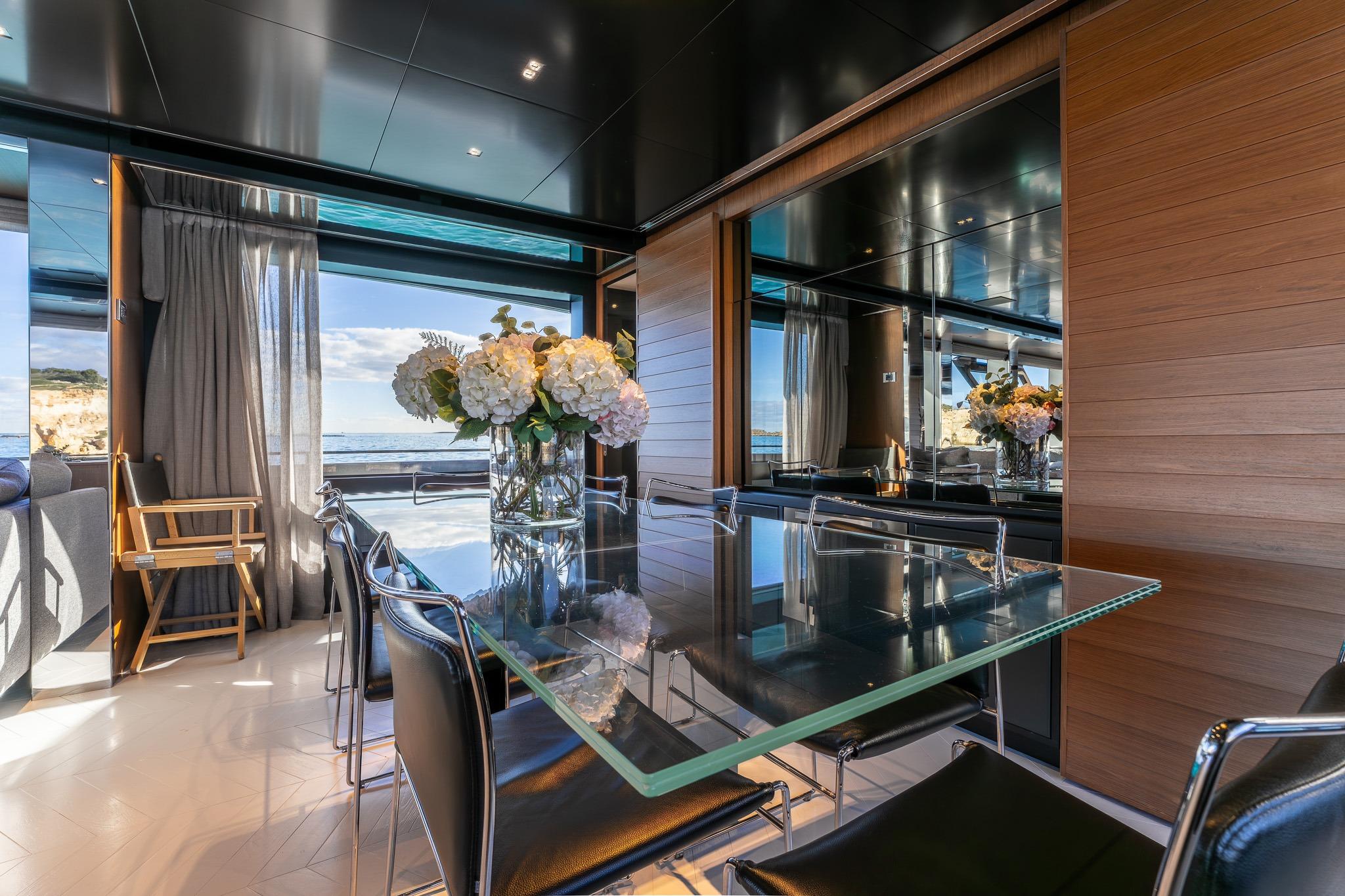Luxurious interior of 2020 Riva 90' Argo yacht with elegant dining area and ocean view.