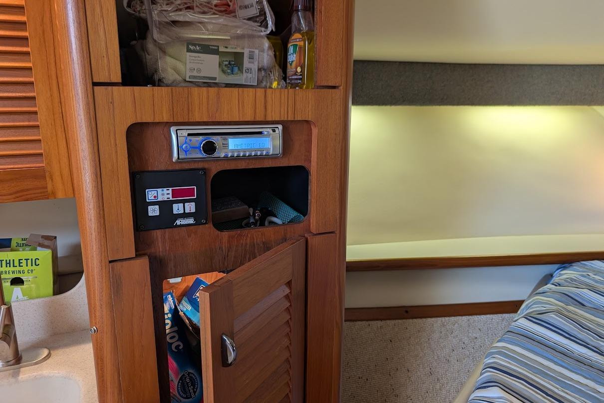 Interior of 2000 Pursuit 3400 Express boat with wooden cabinetry and stereo system.