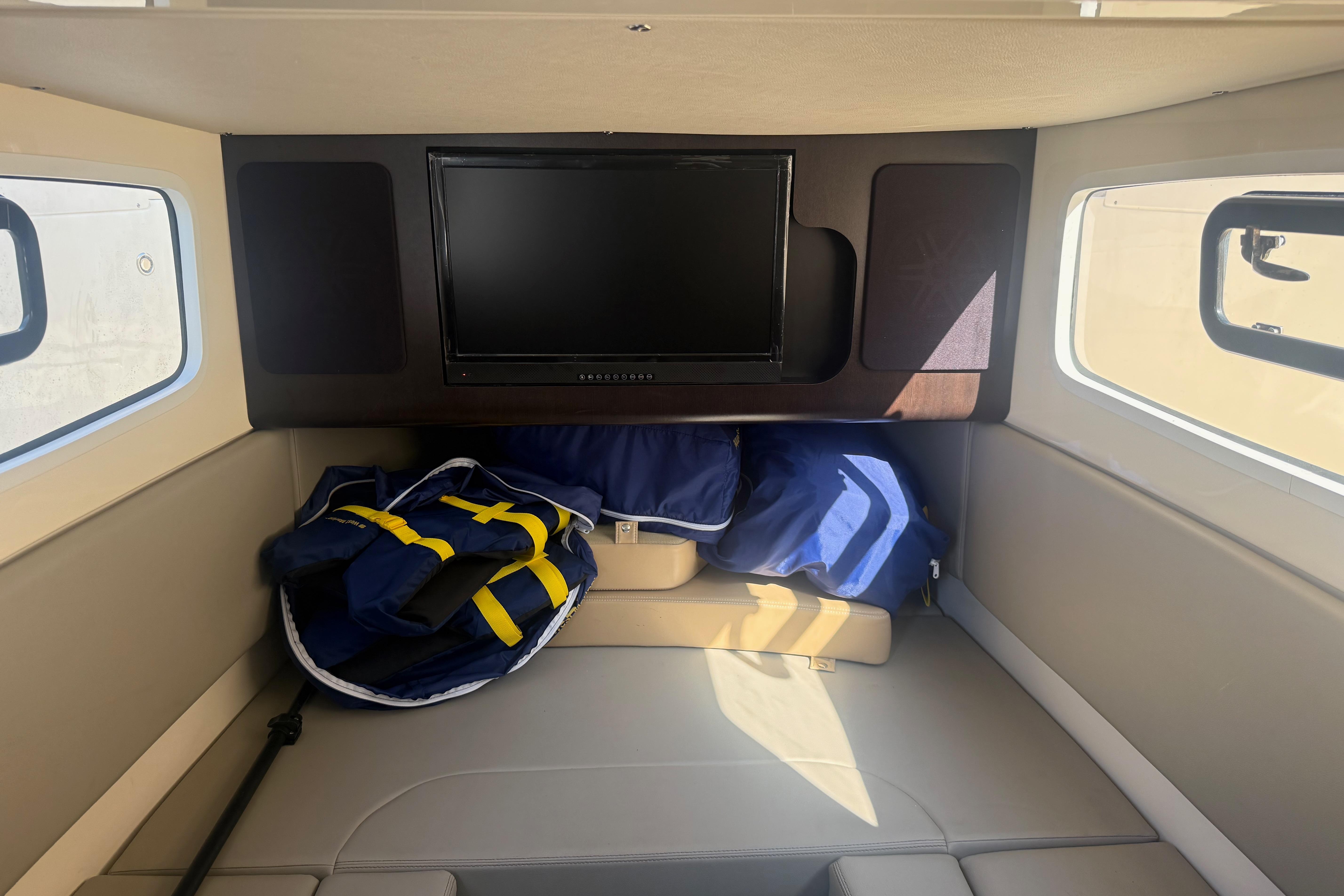 Interior cabin of 2022 Scout 355 LXF boat with TV and life jackets.