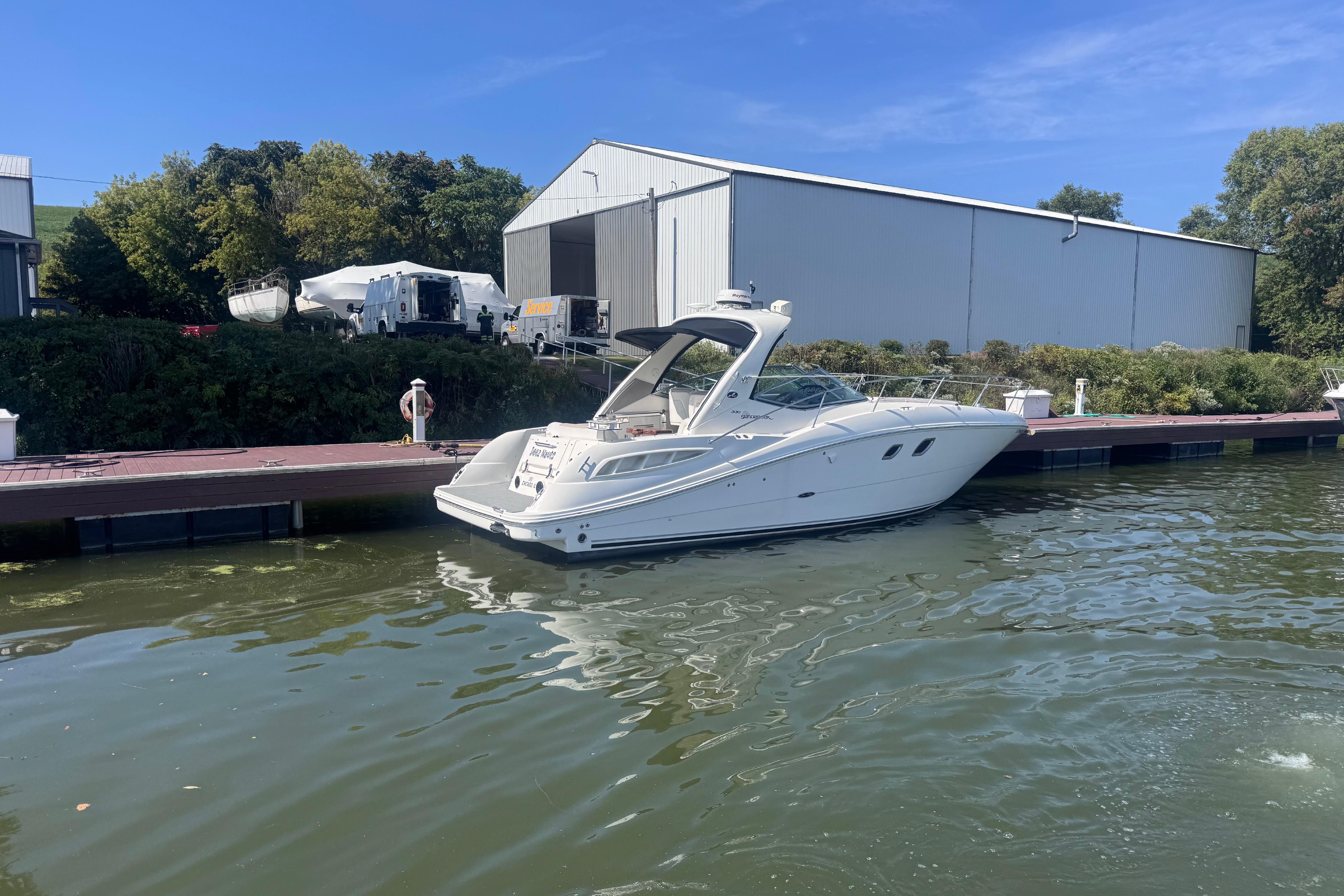 2008 Sea Ray 350 Sundancer docked by a marina with clear blue skies.