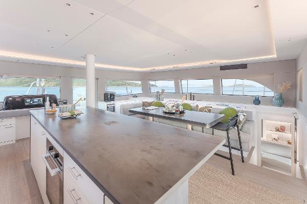 Luxurious interior of 2025 Lagoon SIXTY 5 yacht with modern kitchen and panoramic windows.