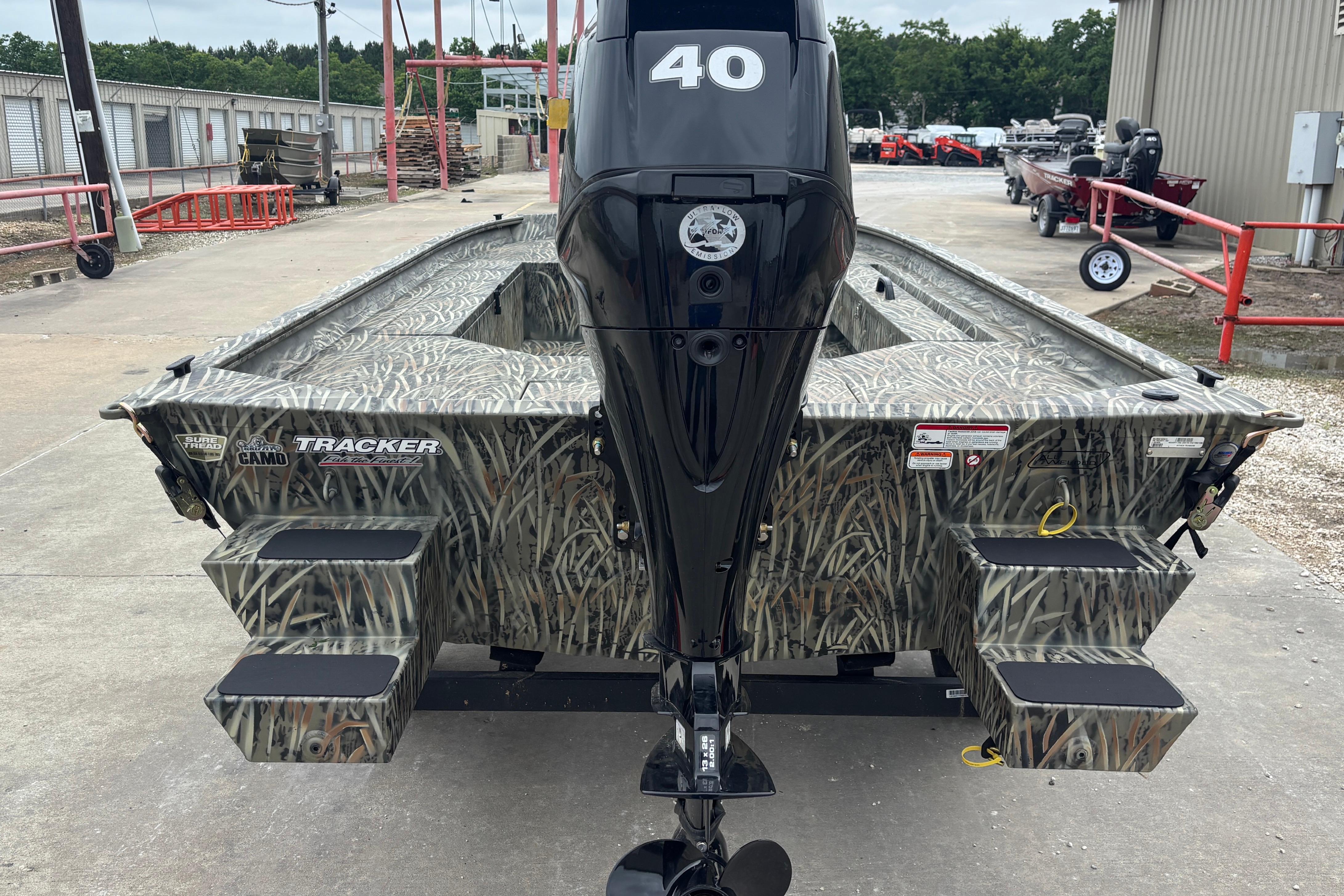 2026 Tracker Grizzly 1654 T Sportsman boat with camouflage design and powerful outboard motor.