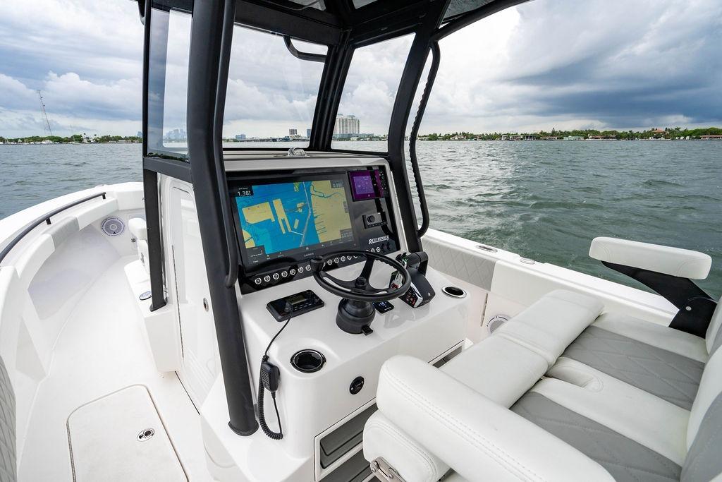 2027 Reef Runner 280 boat cockpit with navigation system on open water.