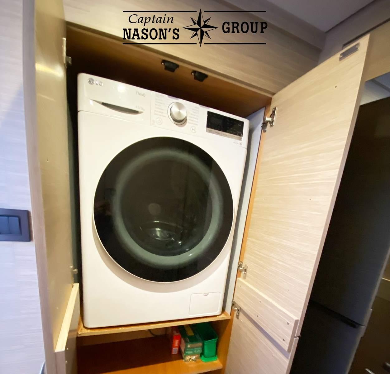 Washing machine in a wooden cabinet on a 2023 Lagoon 46 yacht.