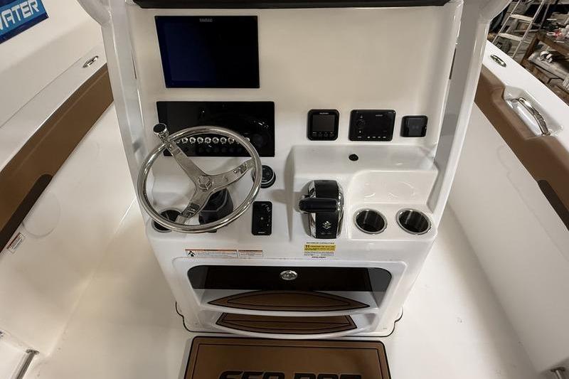 2026 Sea Pro 242 Center Console helm with steering wheel and controls.