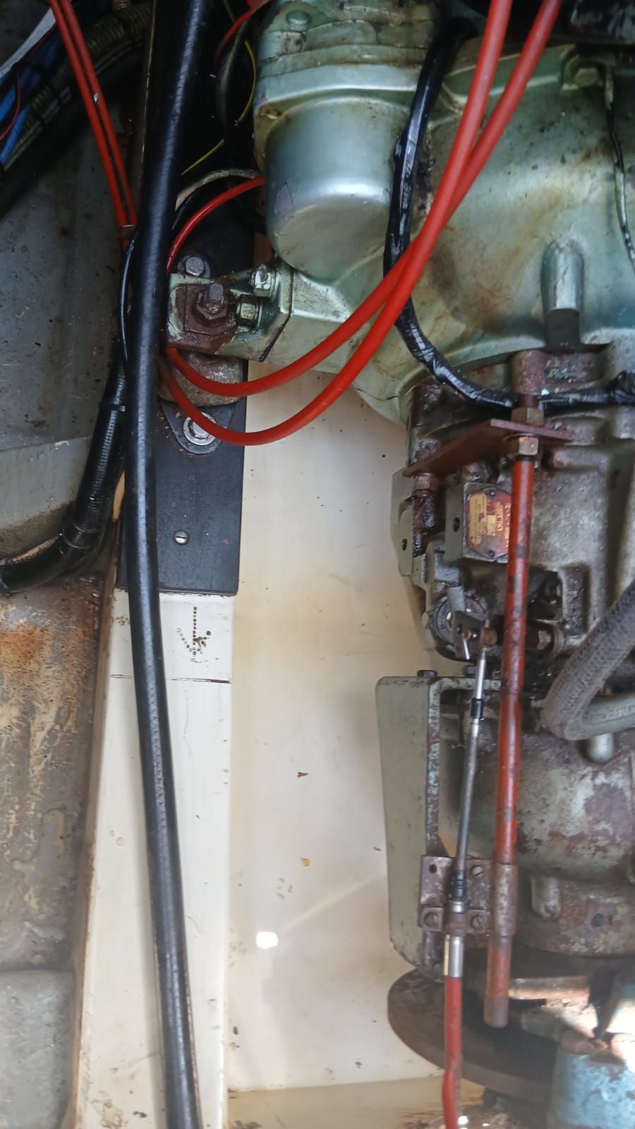 Close-up of a boat engine with red cables and metal components.