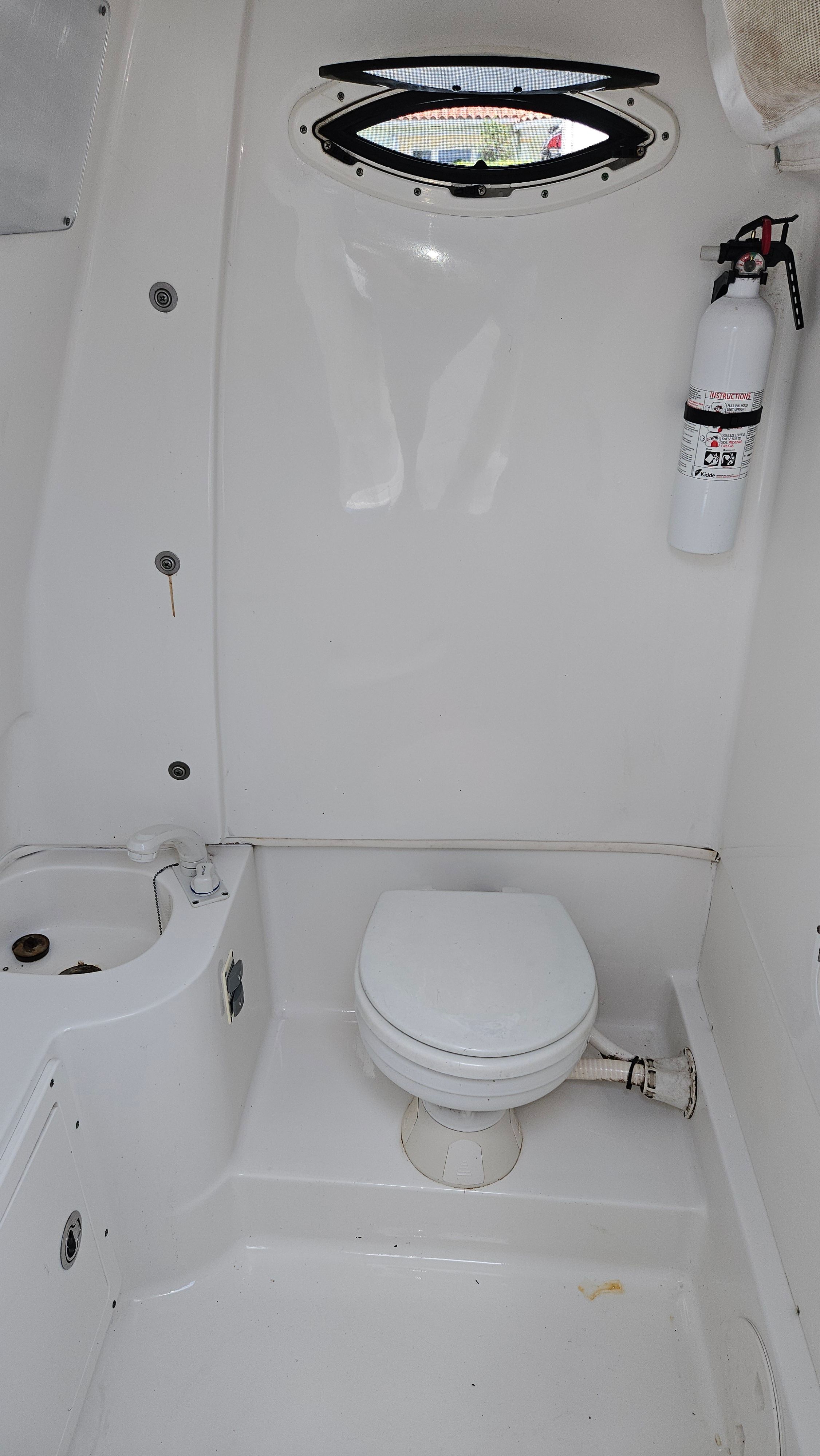 Interior of a Sea Hunt Gamefish 30 with toilet and fire extinguisher.