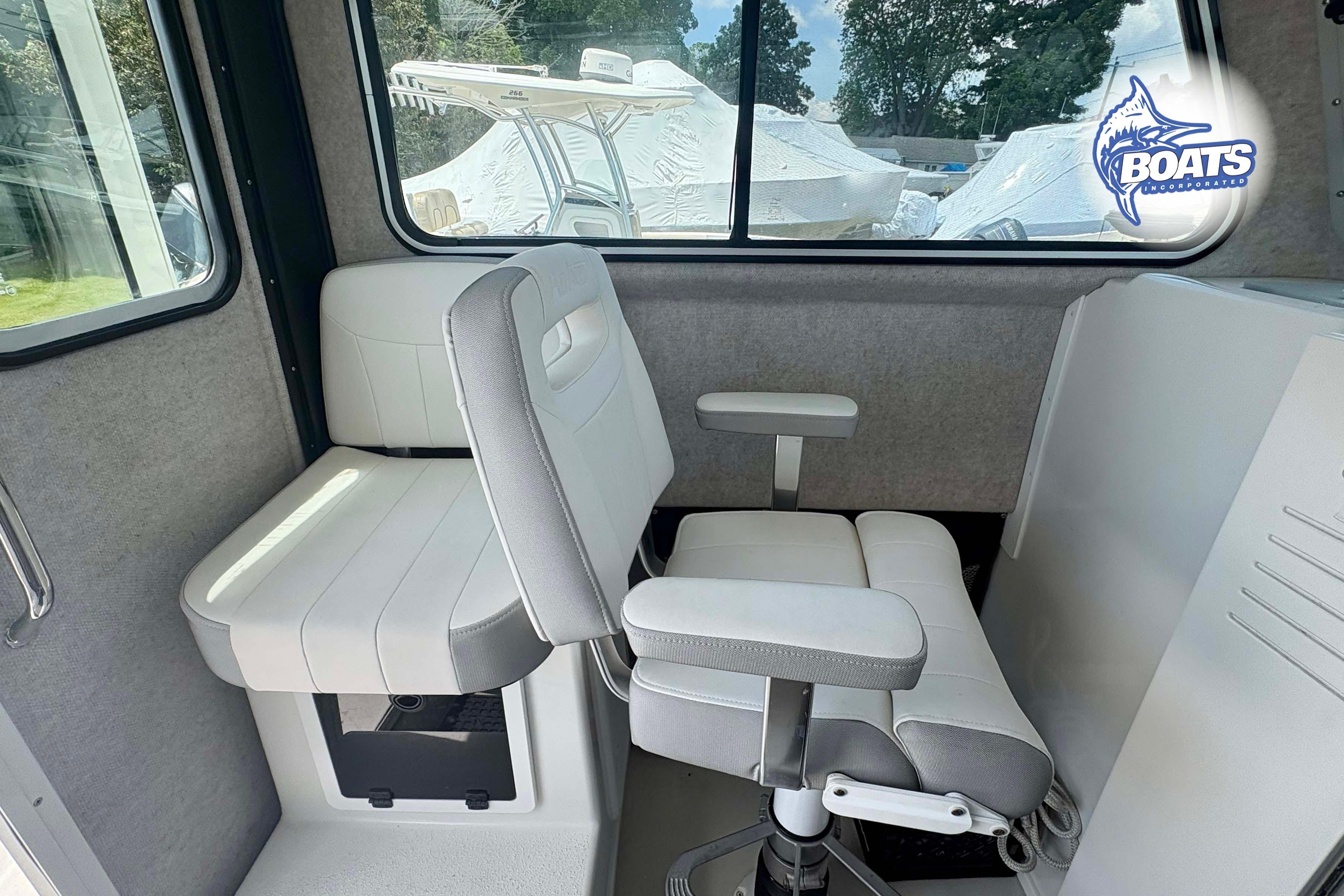 Interior of 2021 Parker 2520 XLD Sport Cabin with white seating and window view.