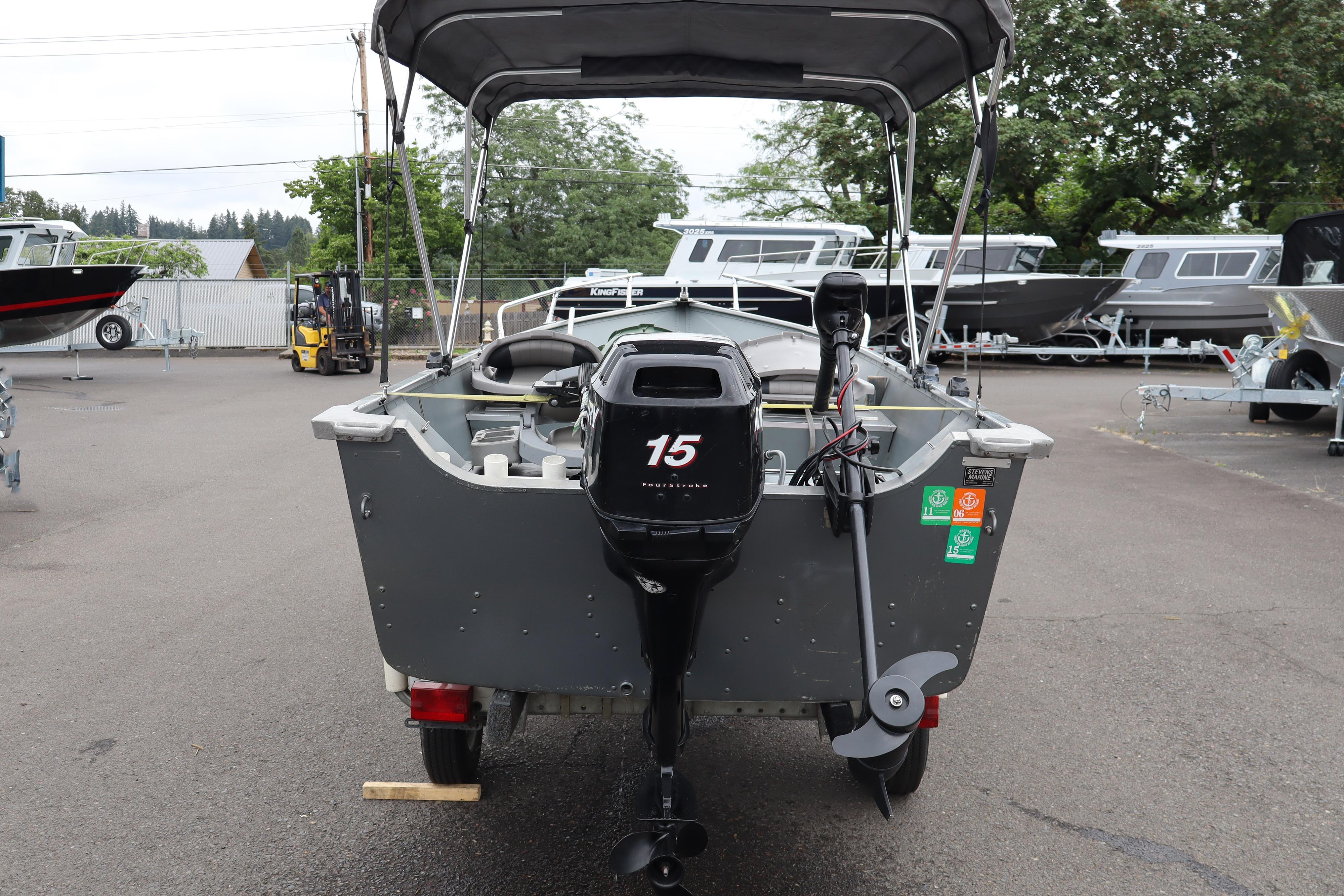 2006 Smoker Craft Alaskan 15 boat with outboard motor, parked in a marina.