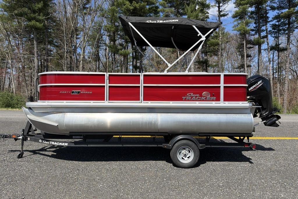 2026 Sun Tracker Party Barge 18 DLX pontoon boat on trailer, parked outdoors.
