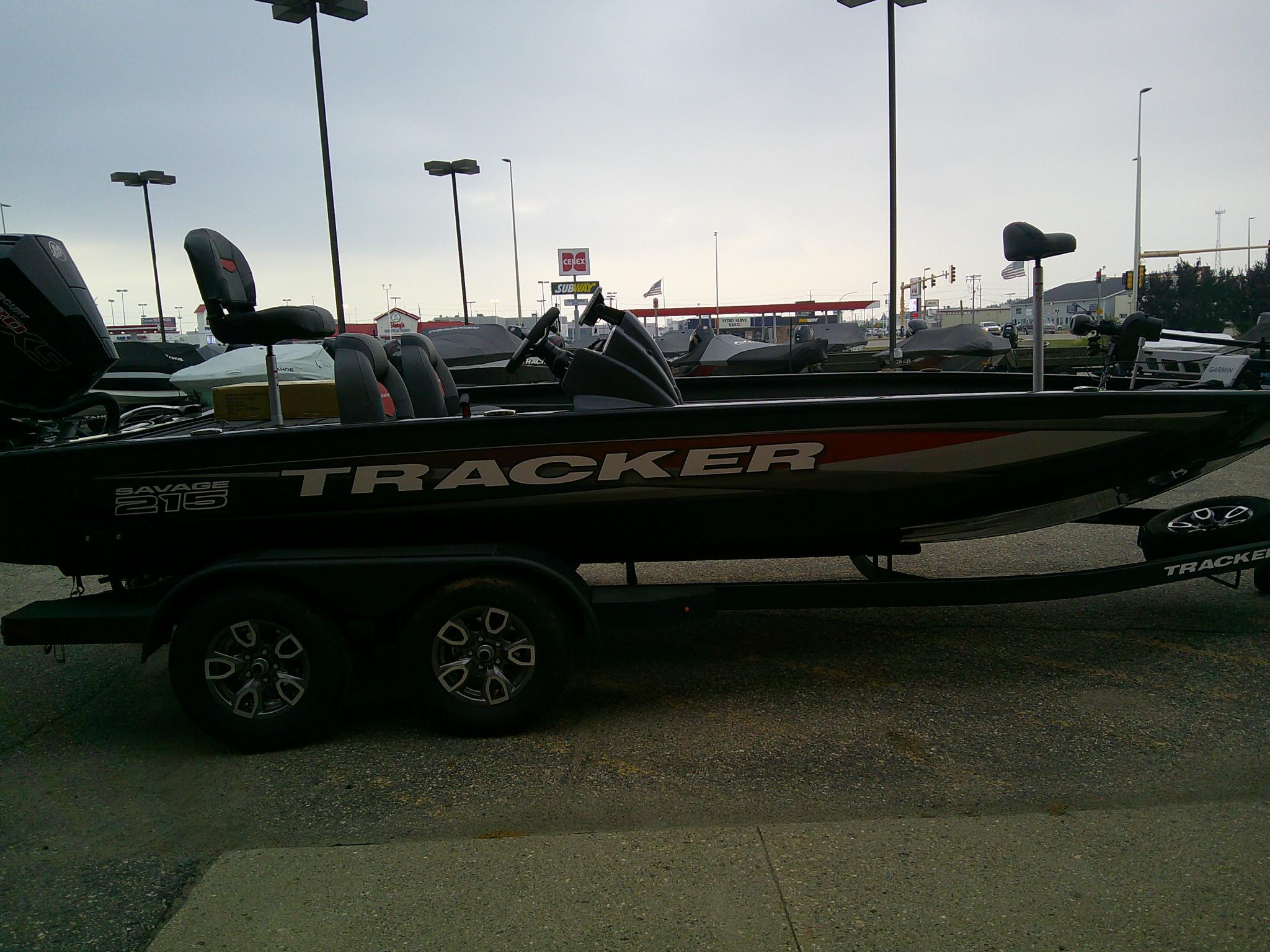 2025 Tracker Savage 215 boat on trailer in parking lot.