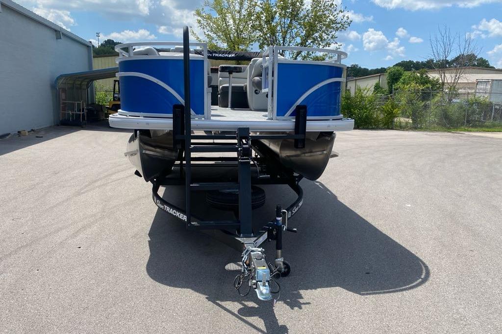 2026 Sun Tracker Fishin' Barge 20 DLX pontoon boat on trailer, parked outdoors.