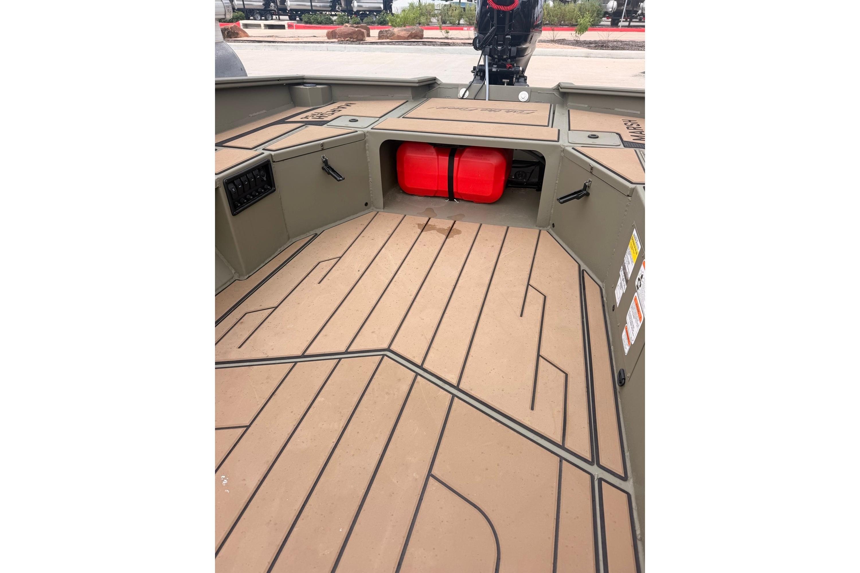 2026 Tracker Grizzly 1756 MARSH boat interior with storage compartments and red fuel tank.