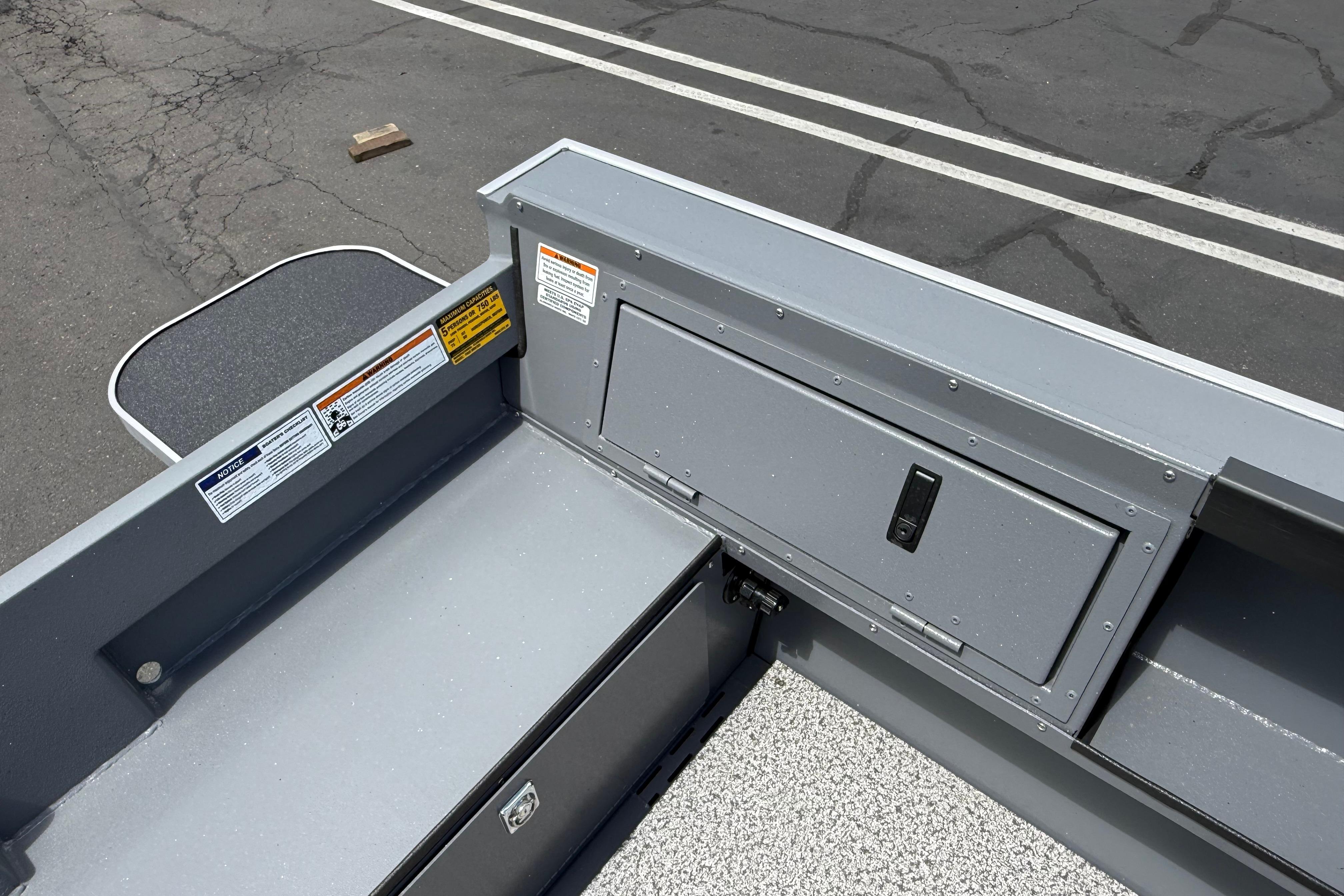 2026 Alumaweld Free Drifter 20 boat interior with storage compartment and safety labels.