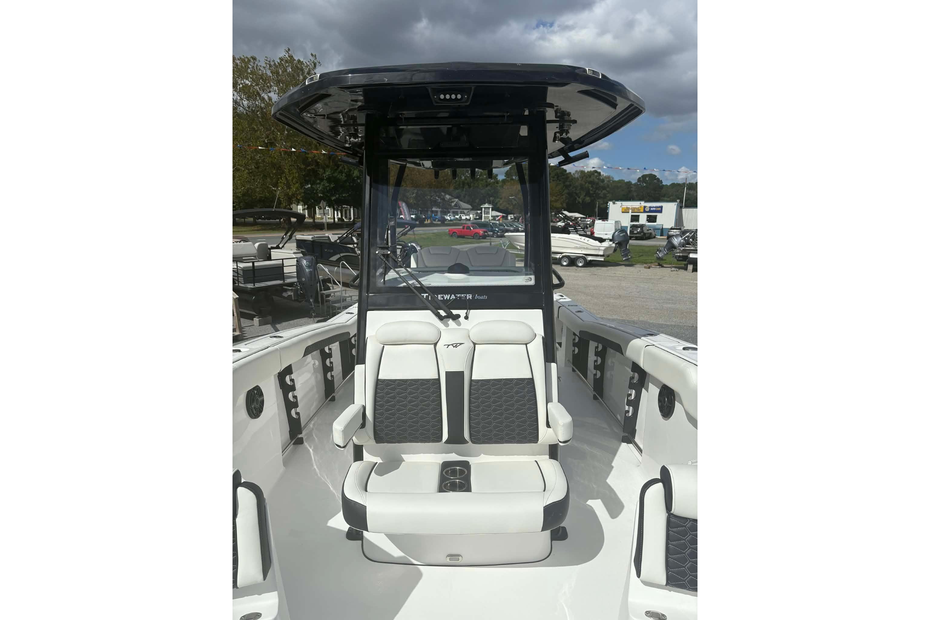 2026 Tidewater 282 CC Adventure boat interior with seating and console under cloudy sky.