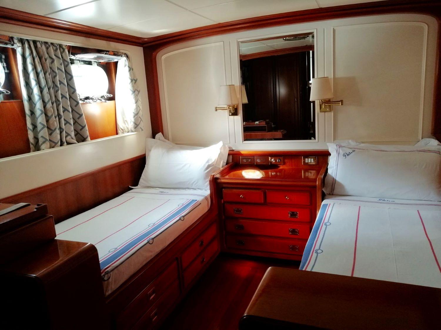 Luxurious cabin interior of 1964 Hall Russell & Co 34 yacht with twin beds and wooden furnishings.