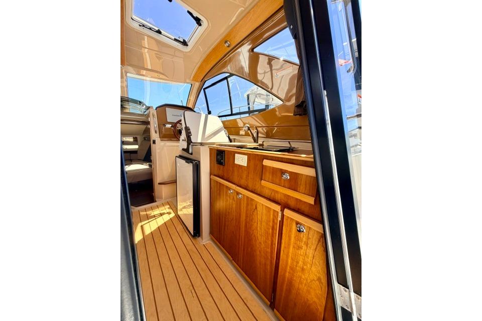 Interior of 2017 Cutwater C-242 Coupe boat, featuring wooden cabinetry and modern design.