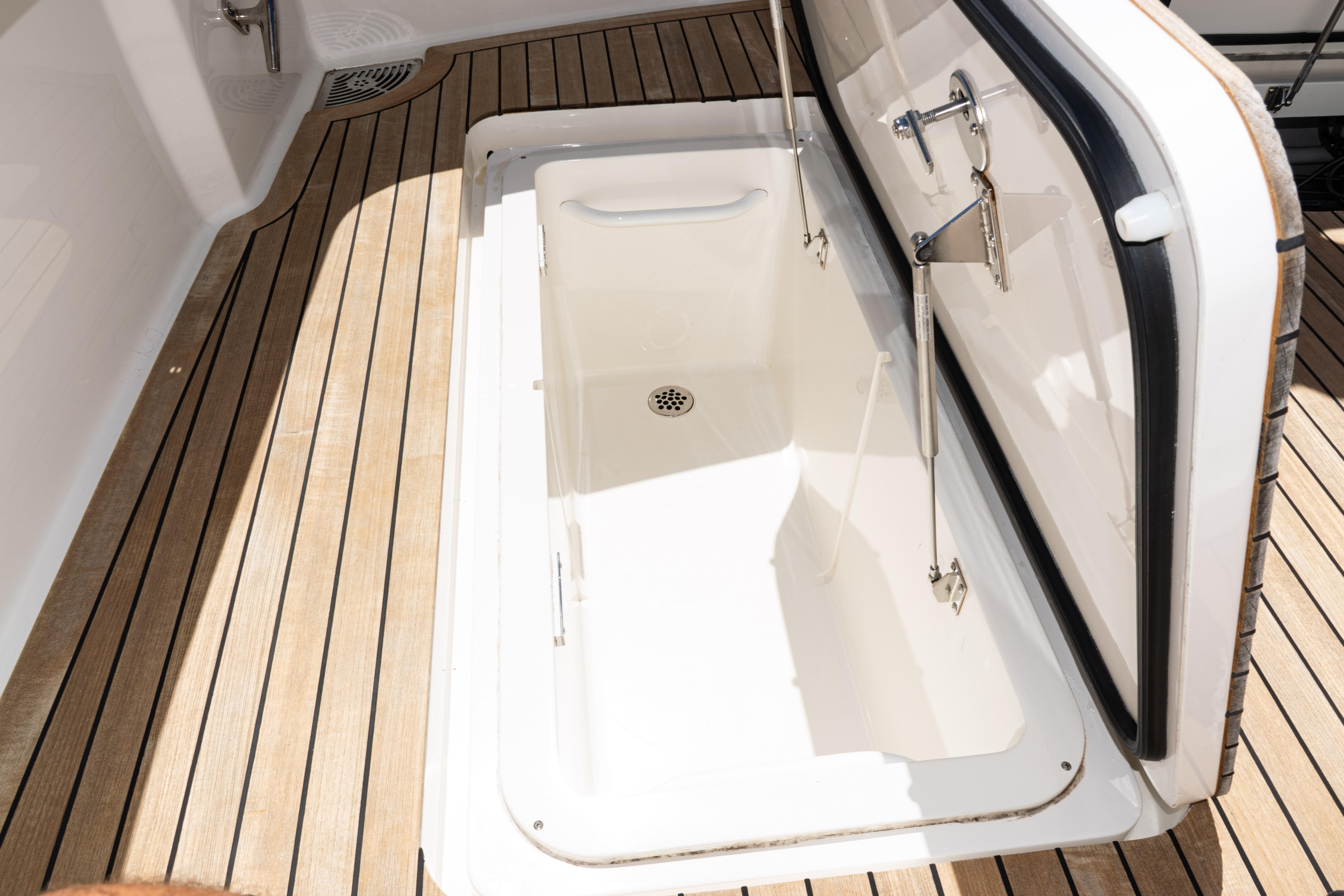 2021 Viking 44 Open yacht storage compartment with teak flooring.