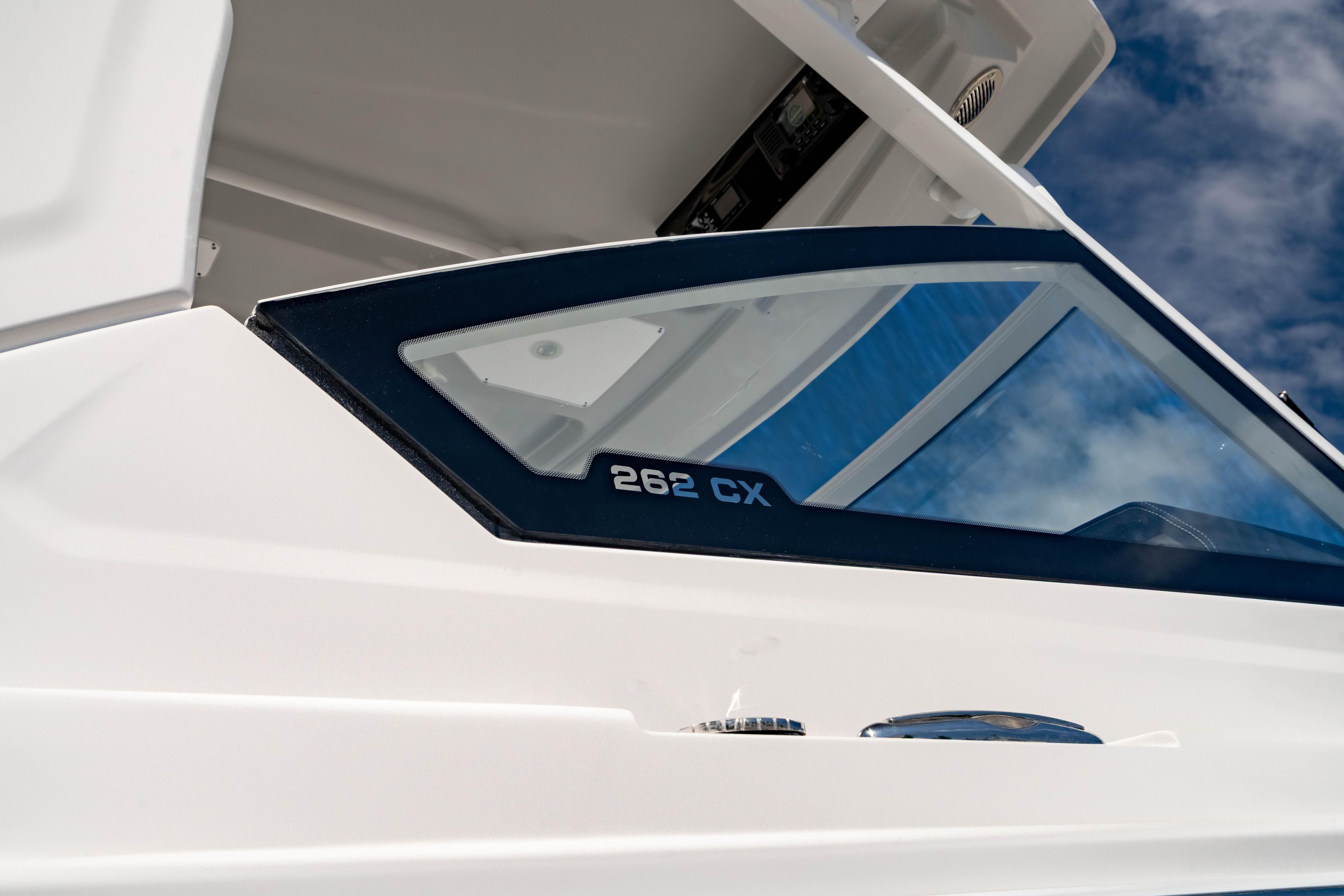 Edgewater 262CX Crossover 2026 boat detail with sleek design and clear blue sky.