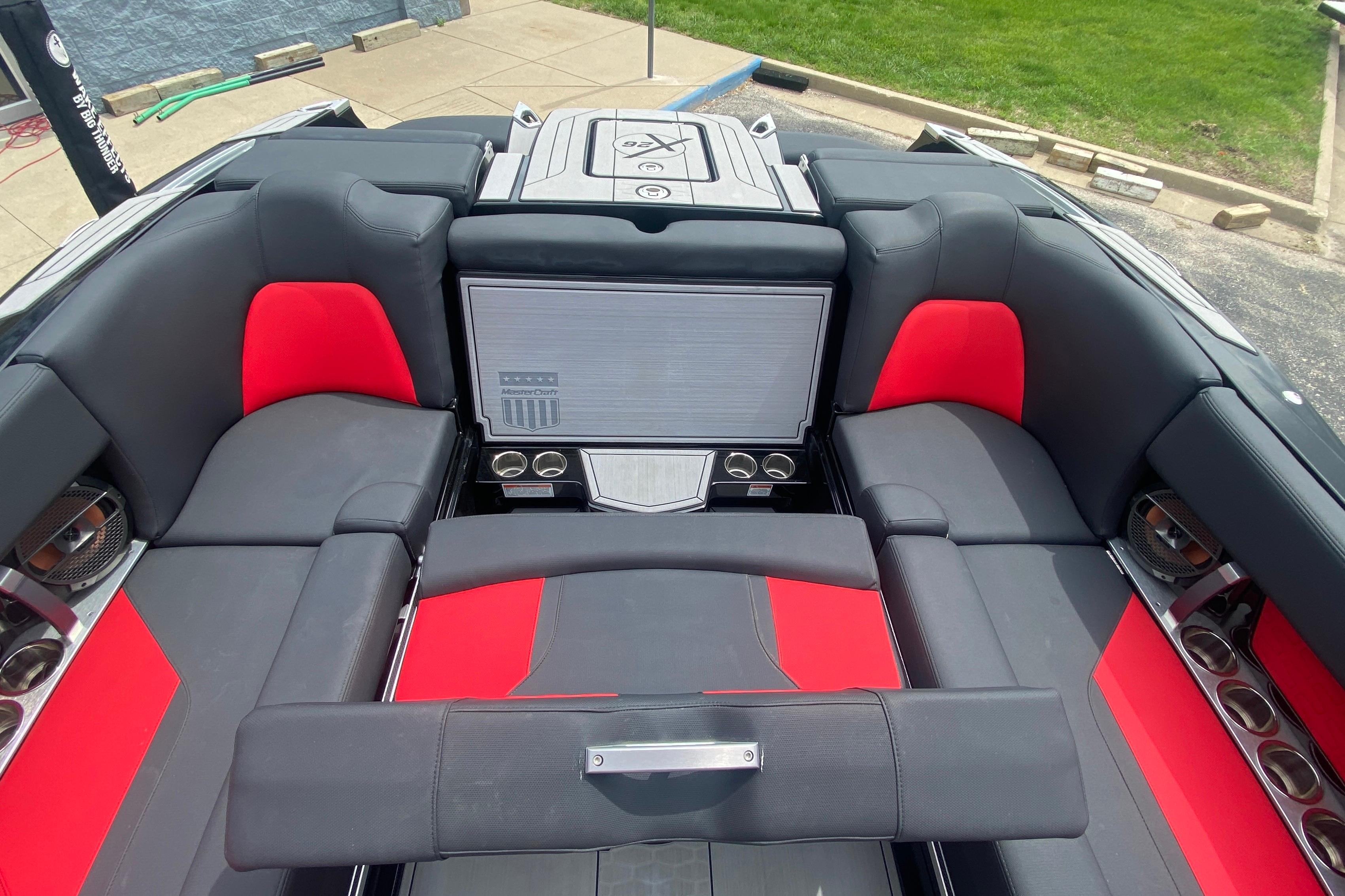 2021 MasterCraft X26 boat interior with red and black seating, cup holders, and premium audio system.