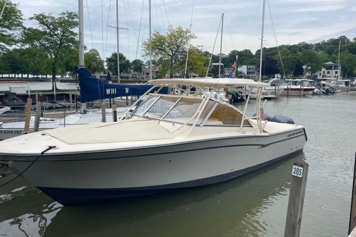 2019 Grady-White Freedom 307 boat docked in a marina with surrounding sailboats.