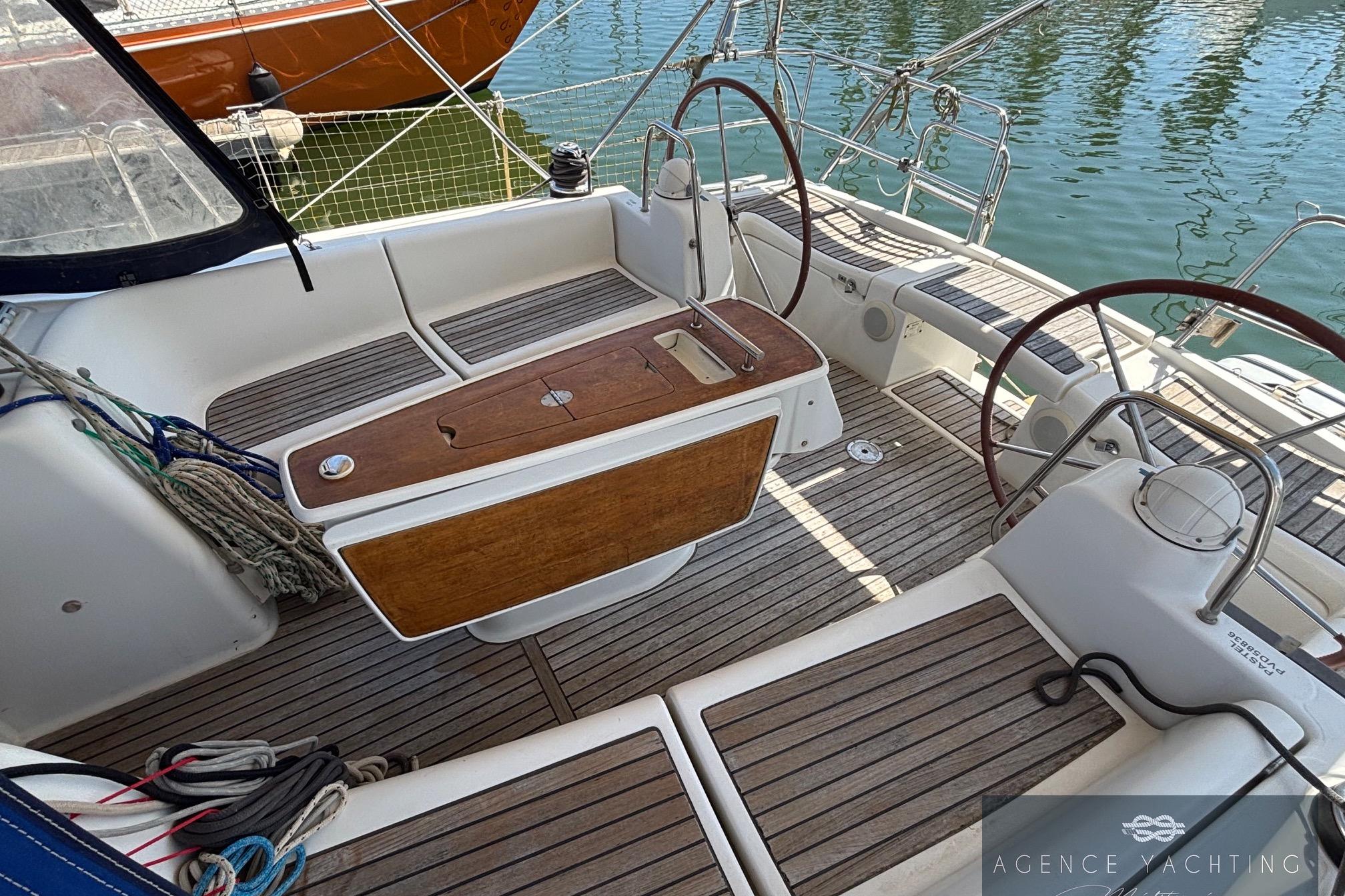 Cockpit of 2008 Beneteau Oceanis 40 sailboat with dual steering wheels and teak flooring.
