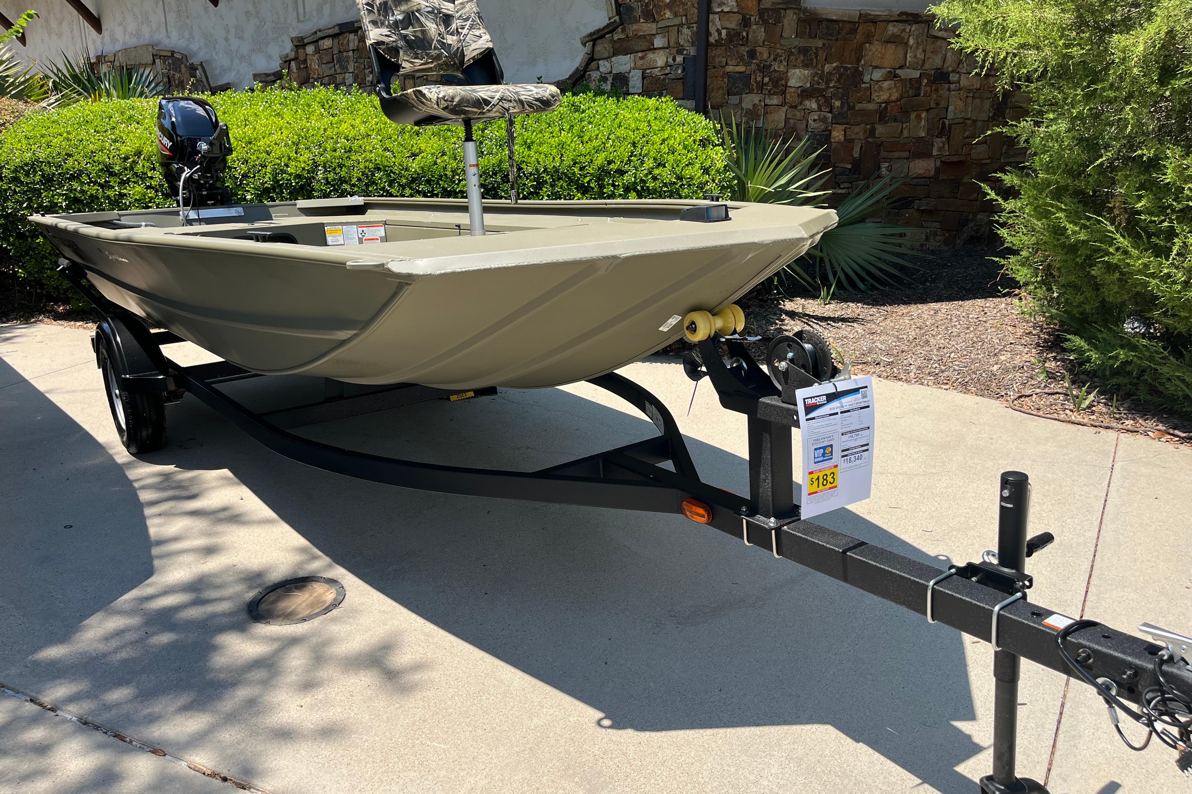 2026 Tracker Grizzly 1654 T Sportsman boat on trailer, parked outdoors.