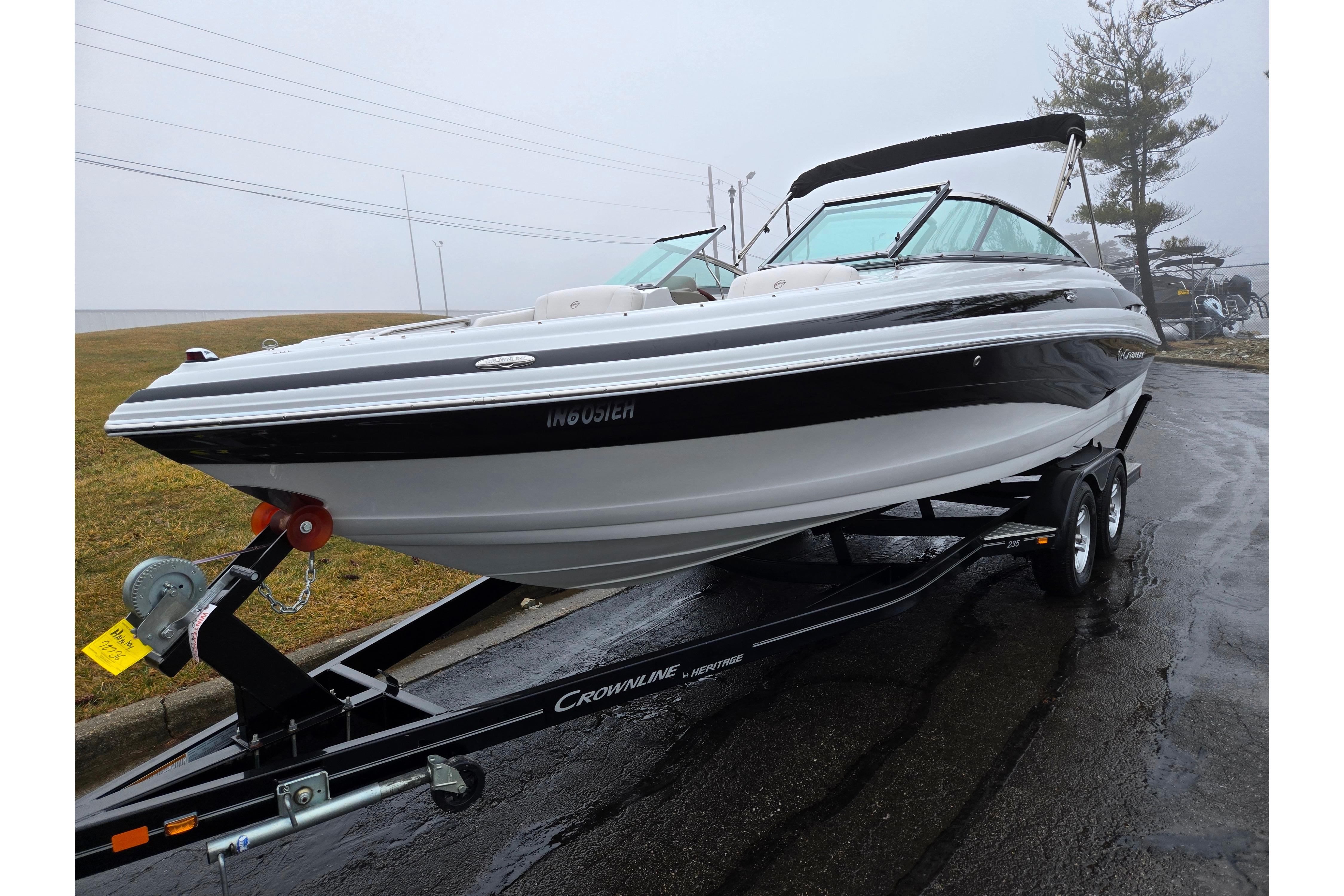 2012 Crownline 235 SS boat on trailer, parked on wet pavement.
