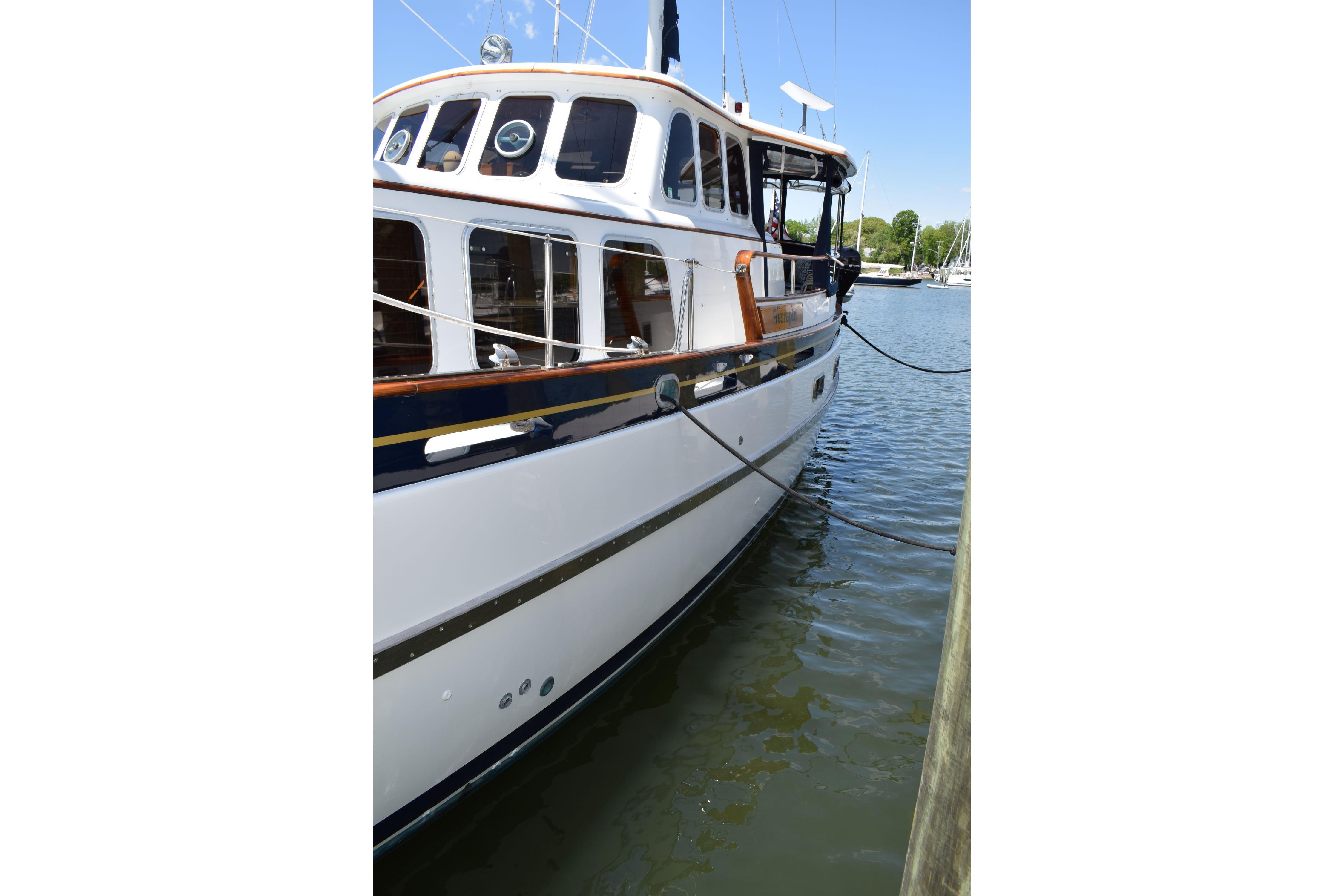 1980 Cheoy Lee 52 Motorsailer docked on calm water, showcasing classic design.